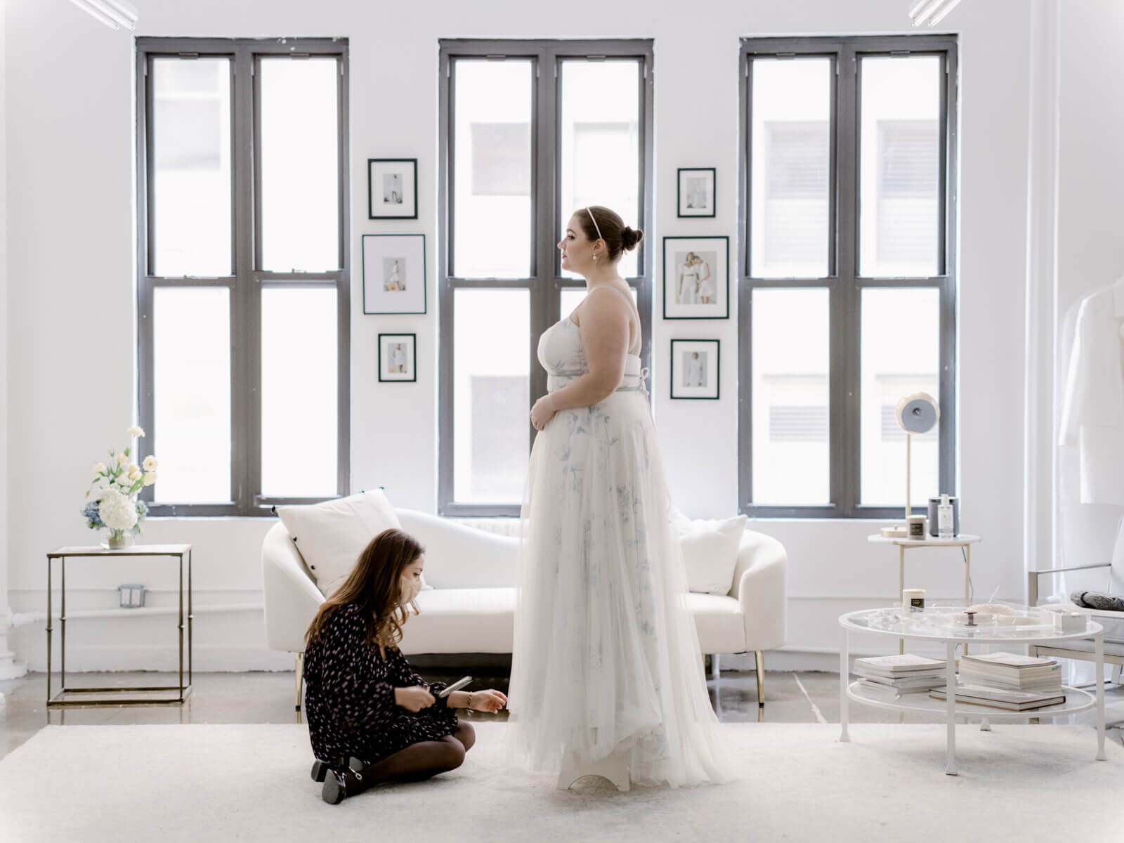 Alexandra Grecco is fixing the hemline of a bridal gown she made for her sister. Image by Jenny Fu Studio