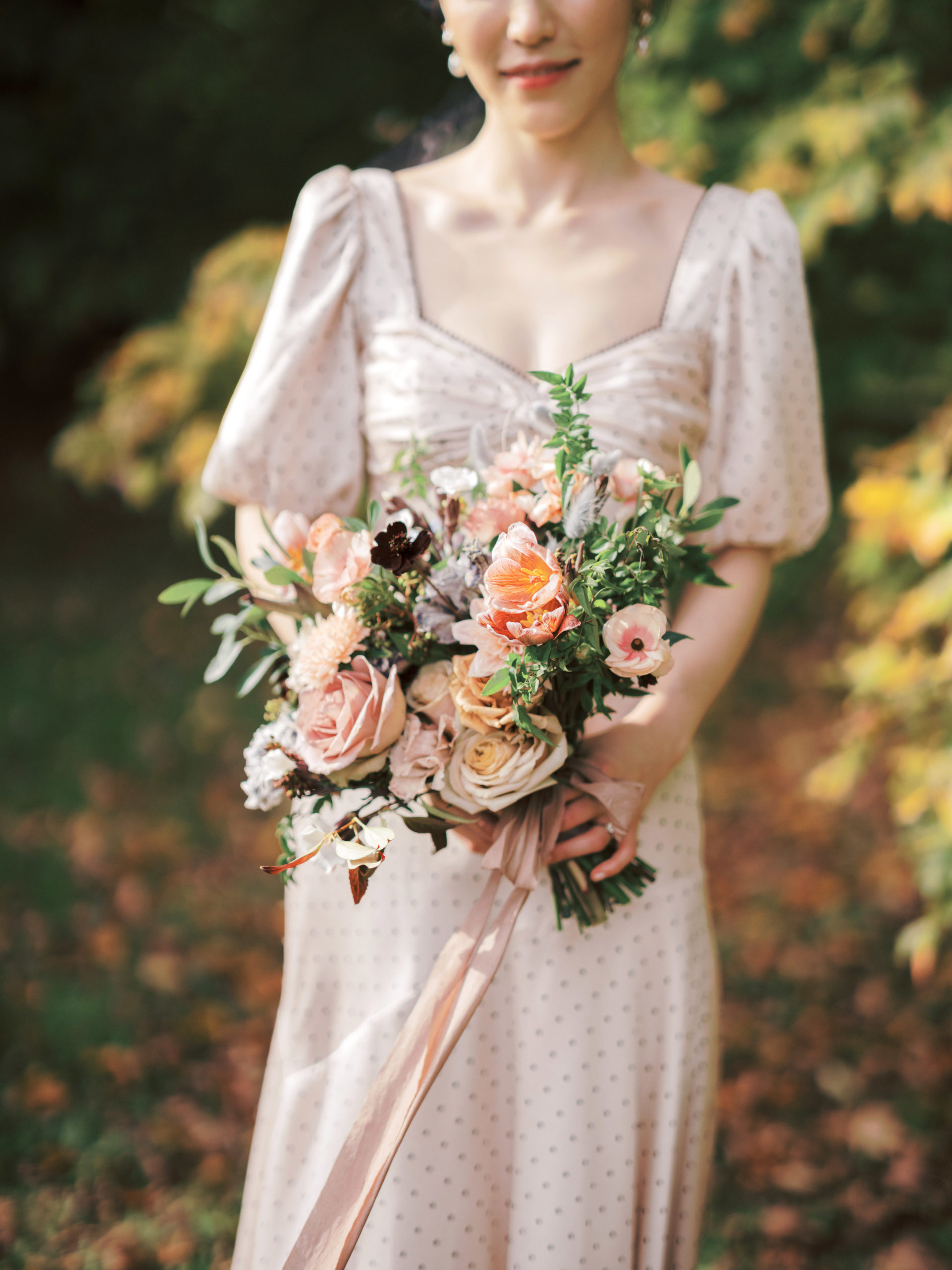 The fiancée is holding a bouquet of beautiful flowers. Engagement session photo by Jenny Fu Studio