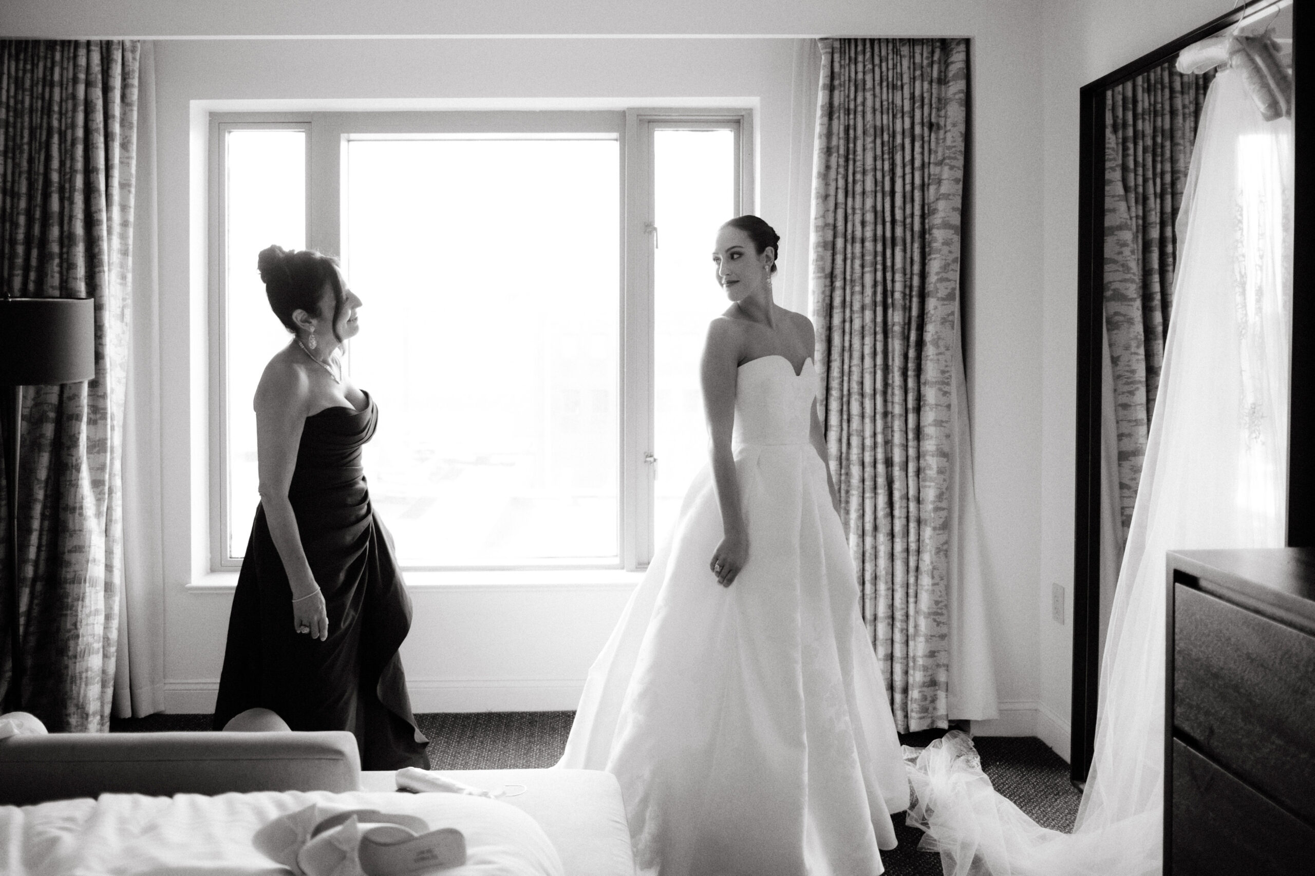 Black and white editorial photo of the bride and her mother while getting ready. Image by Jenny Fu Studio