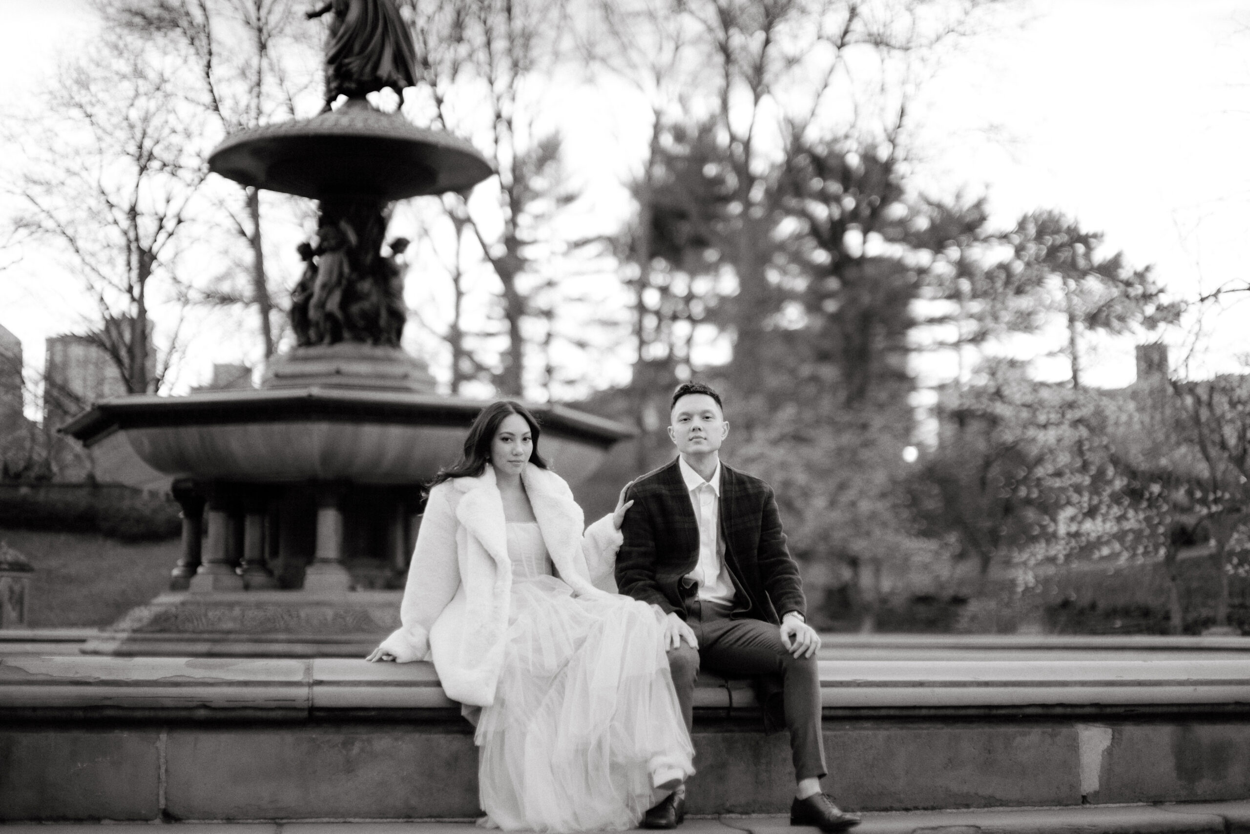 The engaged couple are sitting in Bethesda Fountain, NYC. Engagement Photo image by Jenny Fu Studio
