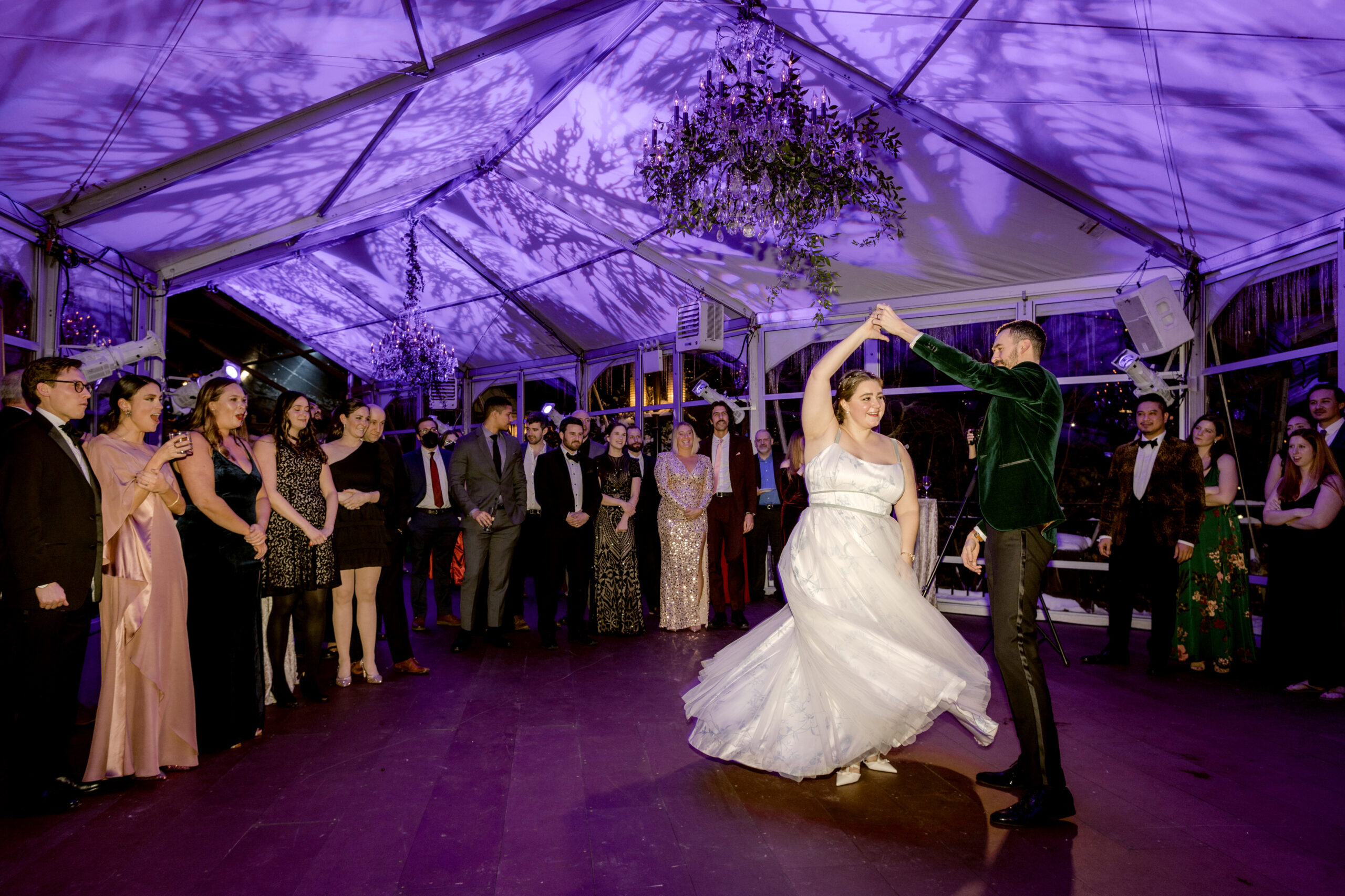 The newlyweds are happily dancing while guests are watching. Editorial image by Jenny Fu Studio