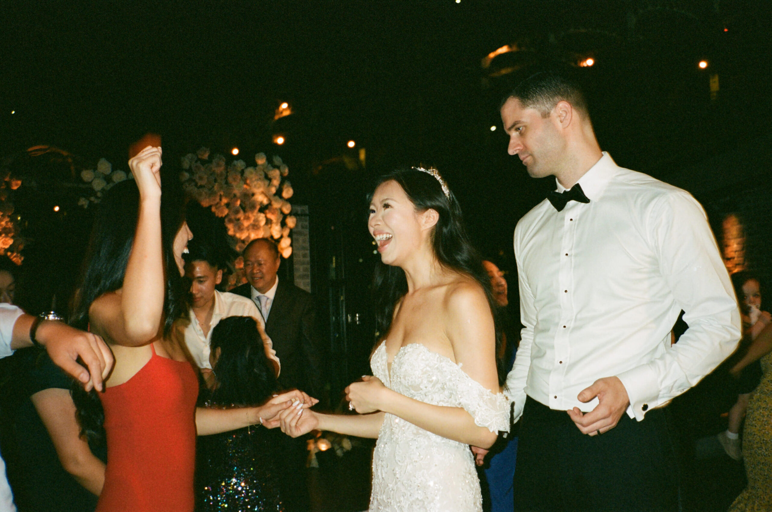 The bride and groom cheerfully talking with a guest. Image by Jenny Fu Studio