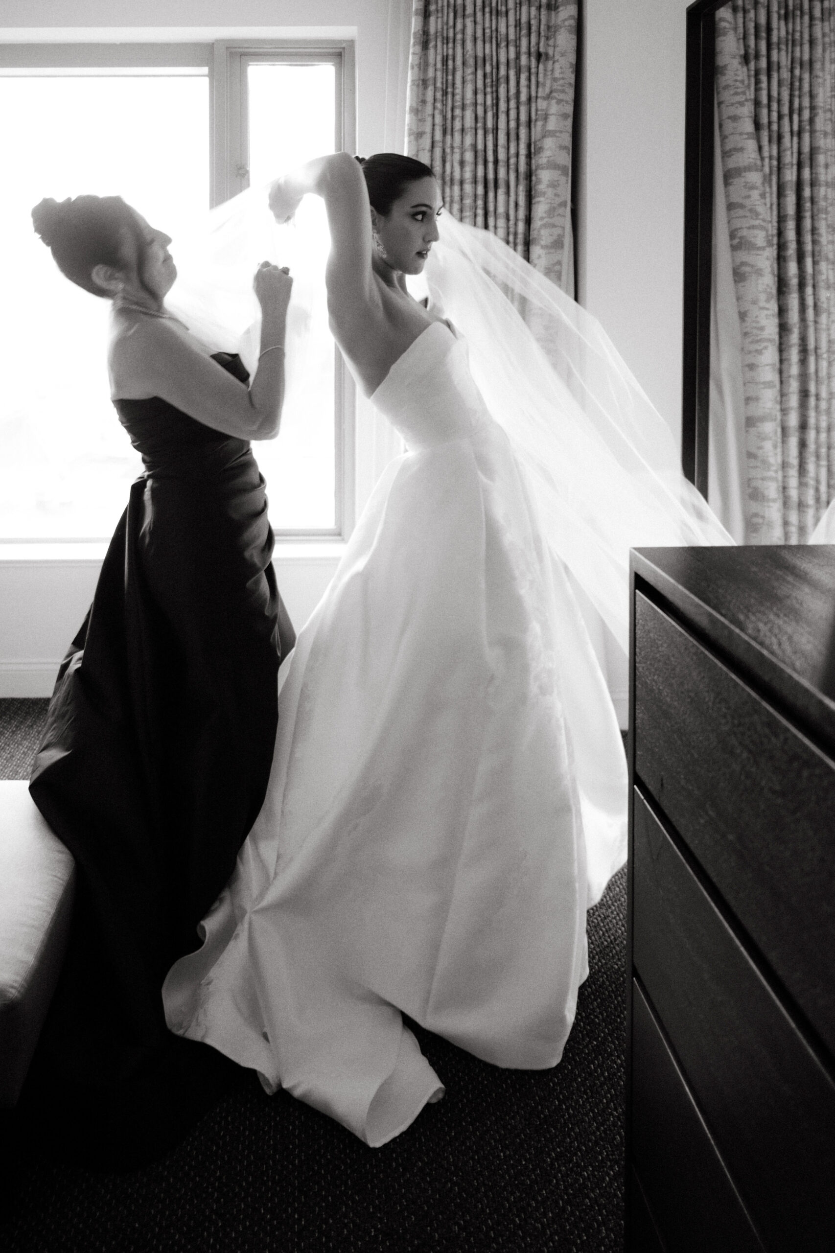 Black and white image of the mother fixing the veil of the Bride. Wedding traditions Image by Jenny Fu Studio
