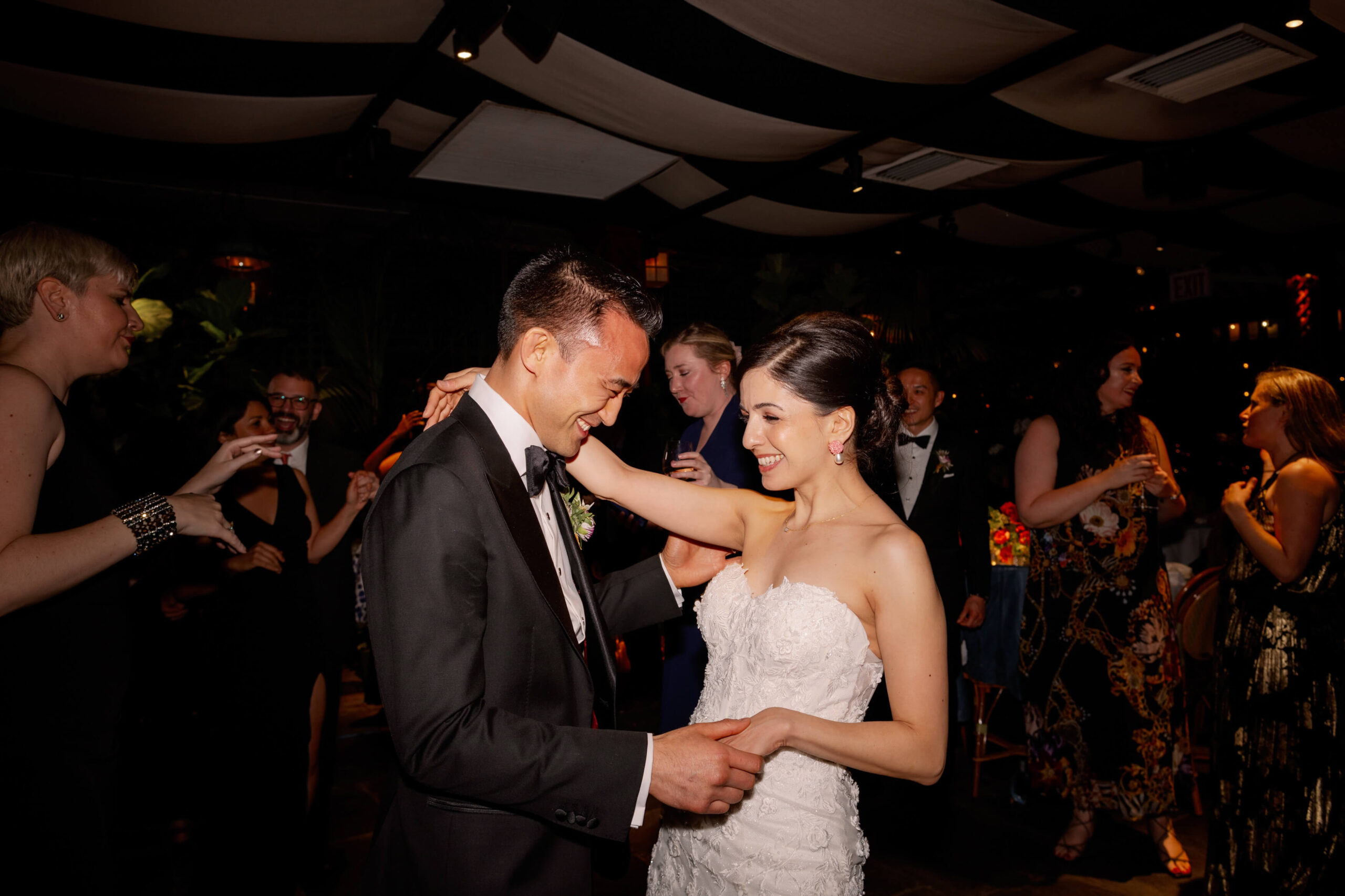The newlyweds are dancing along with the guests on the dance floor. Intimate wedding image by Jenny Fu Studio