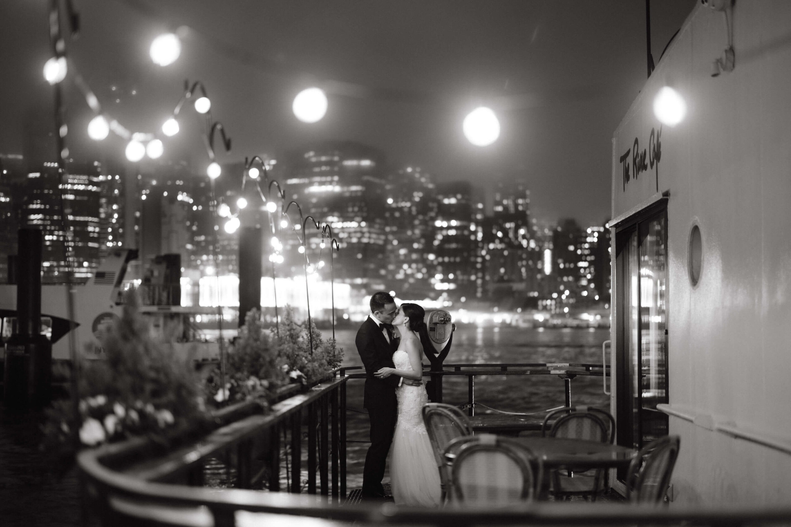 Black and white editorial image of the newlyweds kissing at The River Cafe, NYC. Intimate wedding image by Jenny Fu Studio