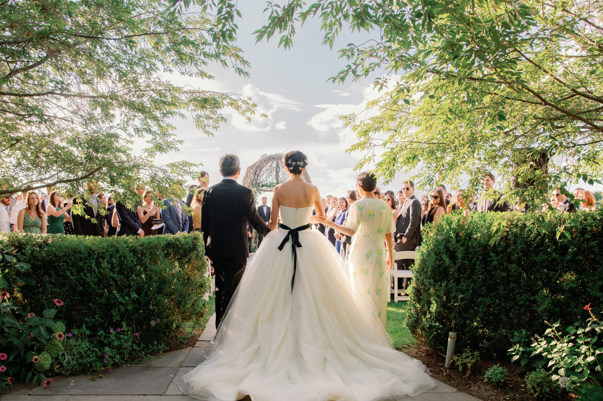 The Bride is walking down the aisle with her mother and father. Image by Jenny Fu Studio
