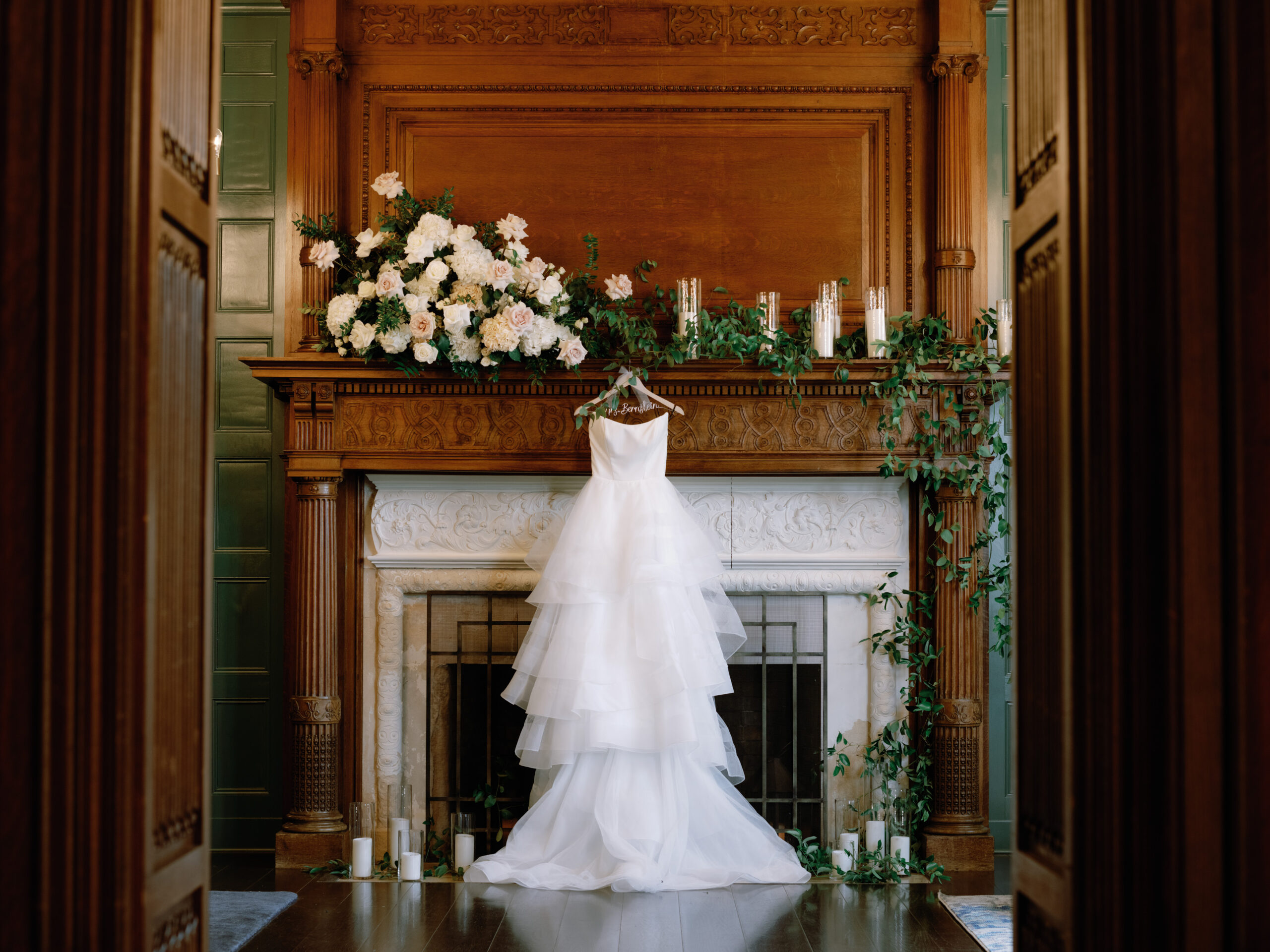 The bride's wedding dress is hanging in front of the fireplace. Timeless wedding photography Image by Jenny Fu Studio