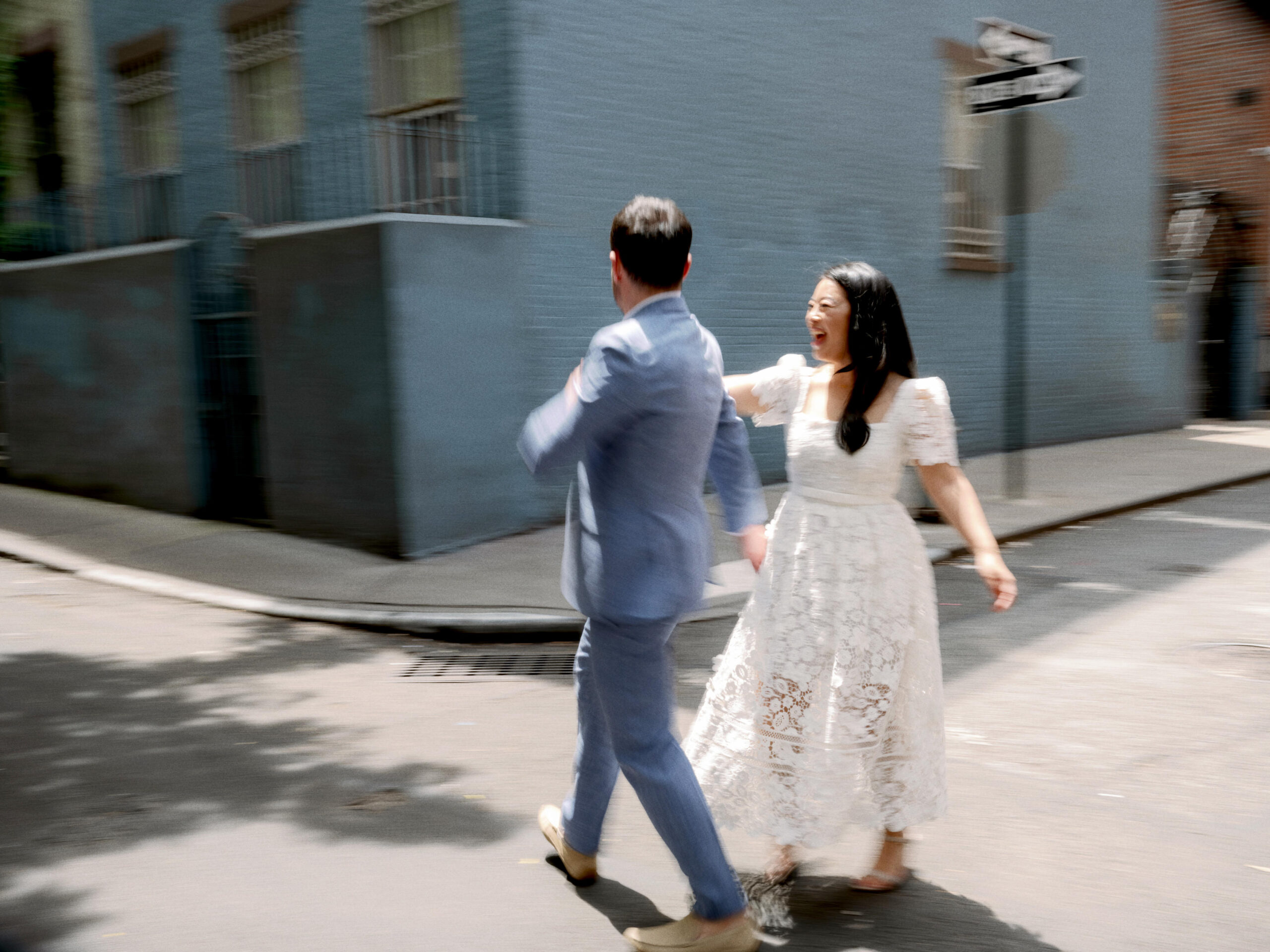The engaged couple are happily dancing in the streets of New York. Engagement photos image by Jenny Fu Studio