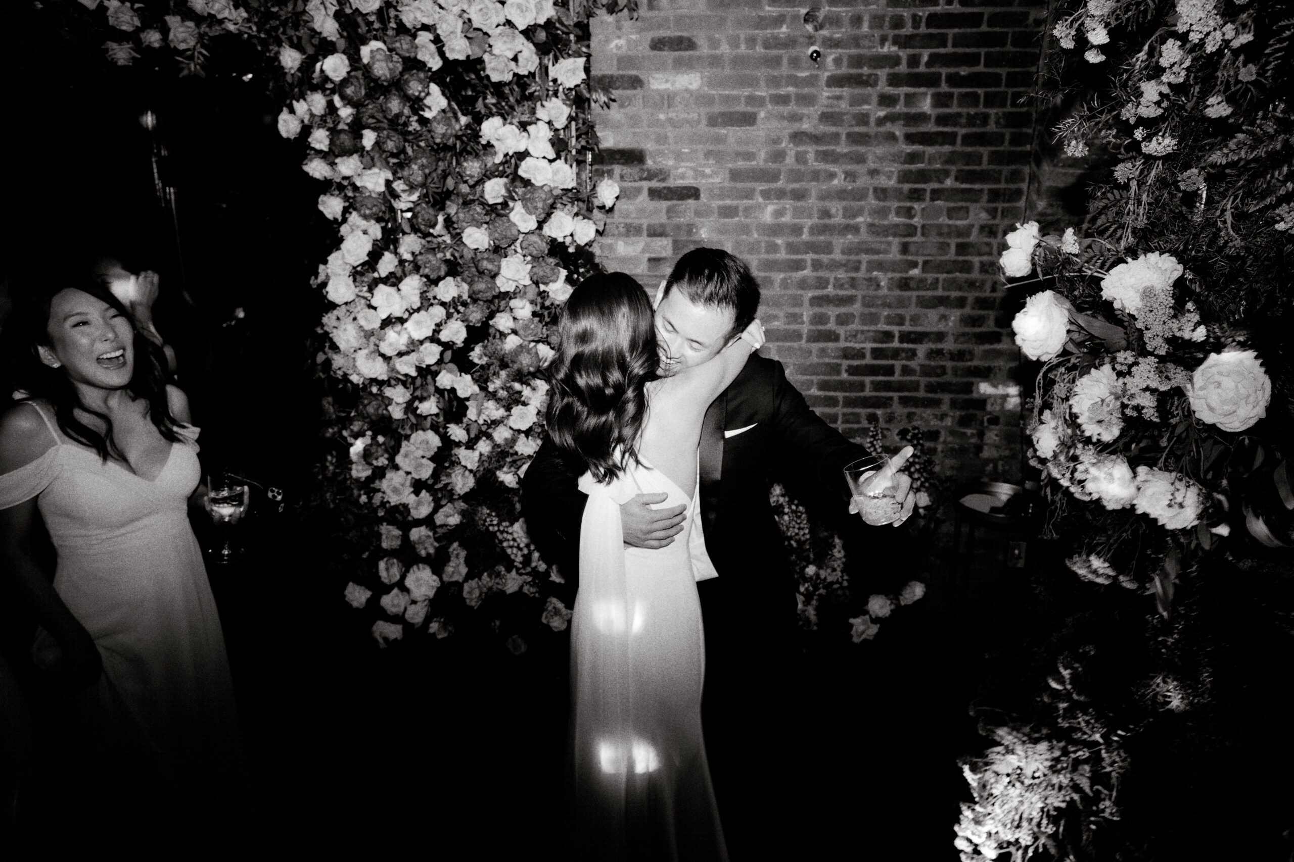 Black and white image of the bride and groom hugging on the dance floor. Editorial image by Jenny Fu Studio