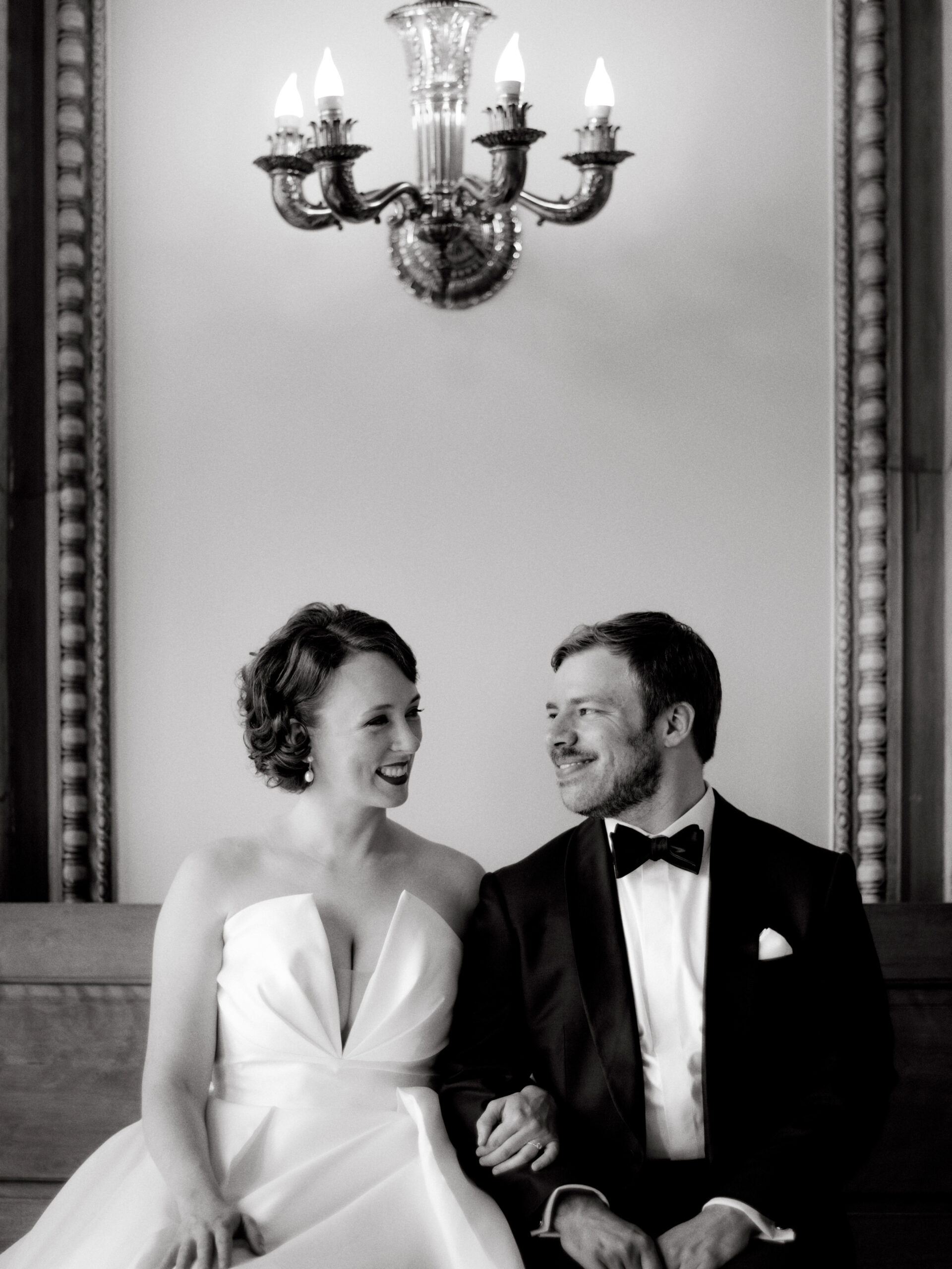 Black and white, editorial image of the bride and groom sitting close to each other. Image by Jenny Fu Studio