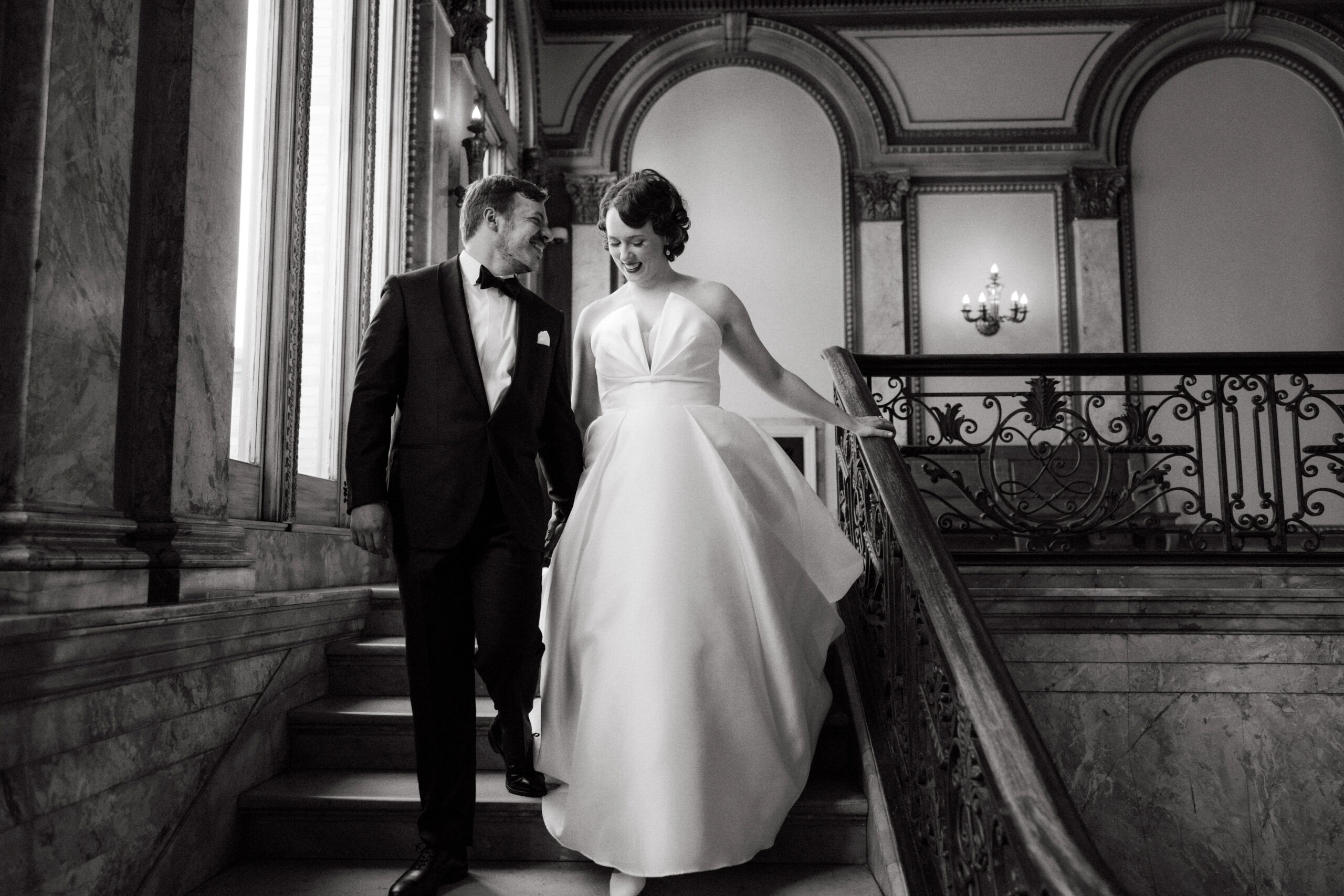 Black and white image of the  bride and groom walking down the staircase. Wedding poses image by Jenny Fu Studio