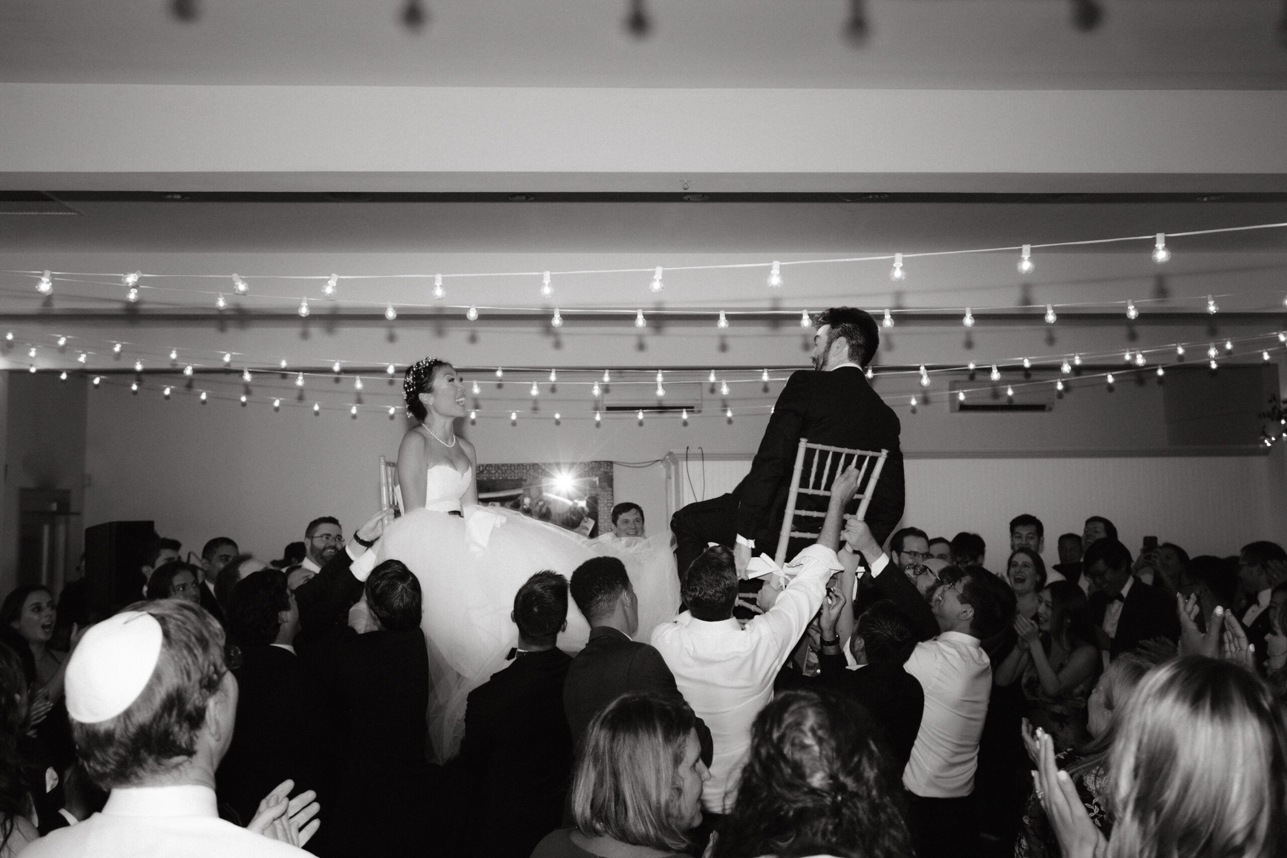 Editorial image of the bride and groom having fun in the wedding reception. Image by Jenny Fu Studio
