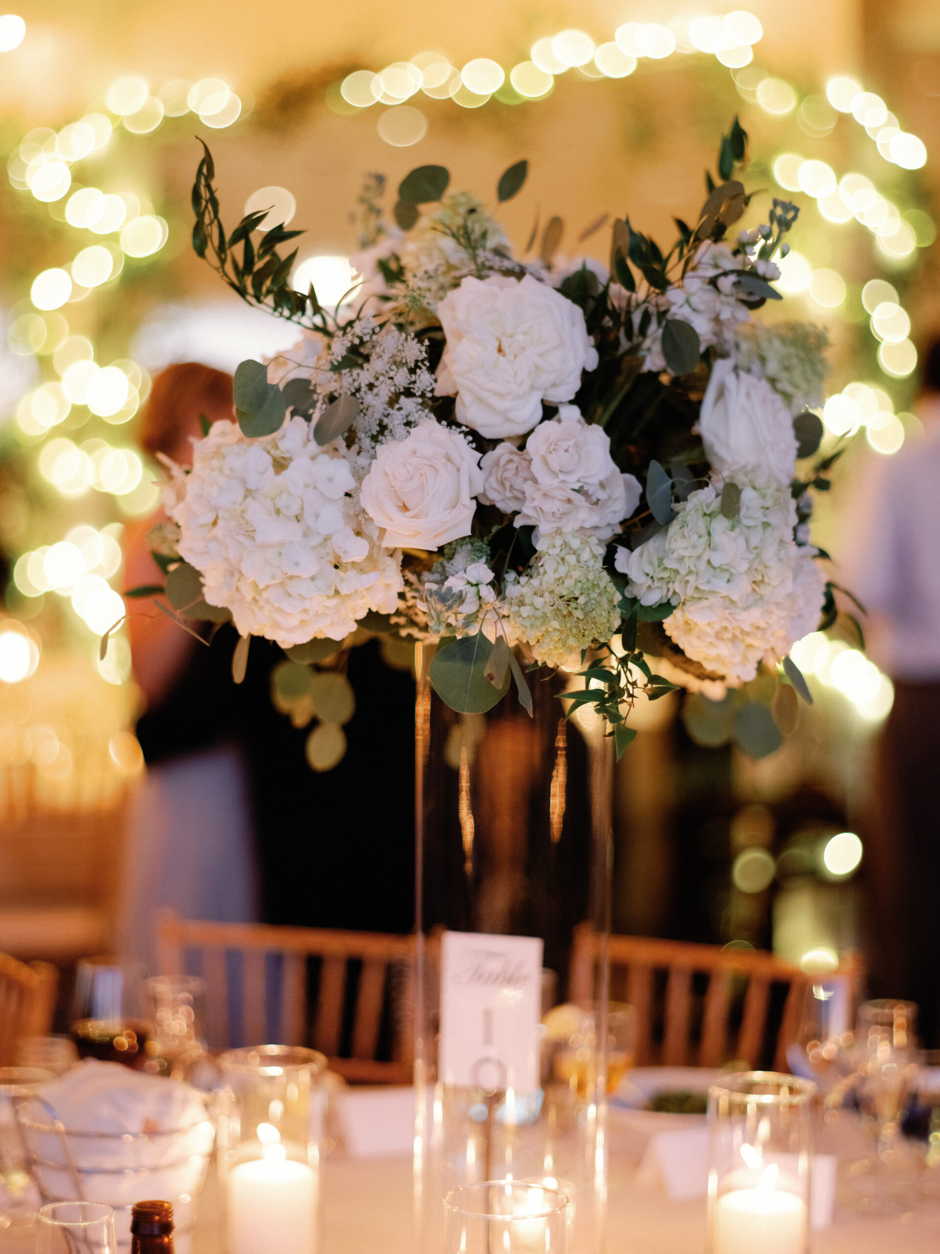 A flower bouquet centerpiece on a wedding dining table. Image by Jenny Fu Studio