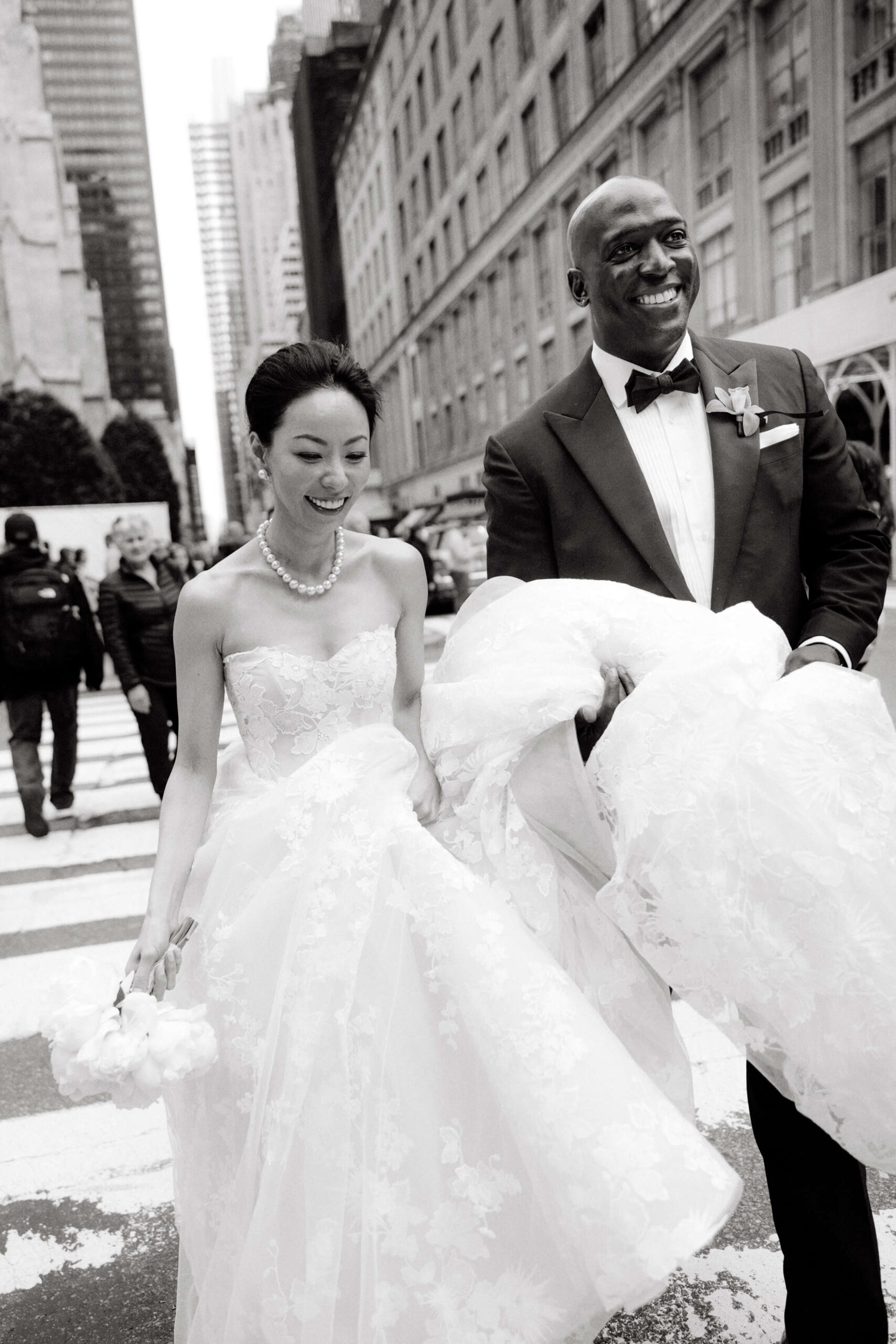 Black and white image of the bride and groom crossing the streets of NYC. Wedding photography styles image by Jenny Fu Studio
