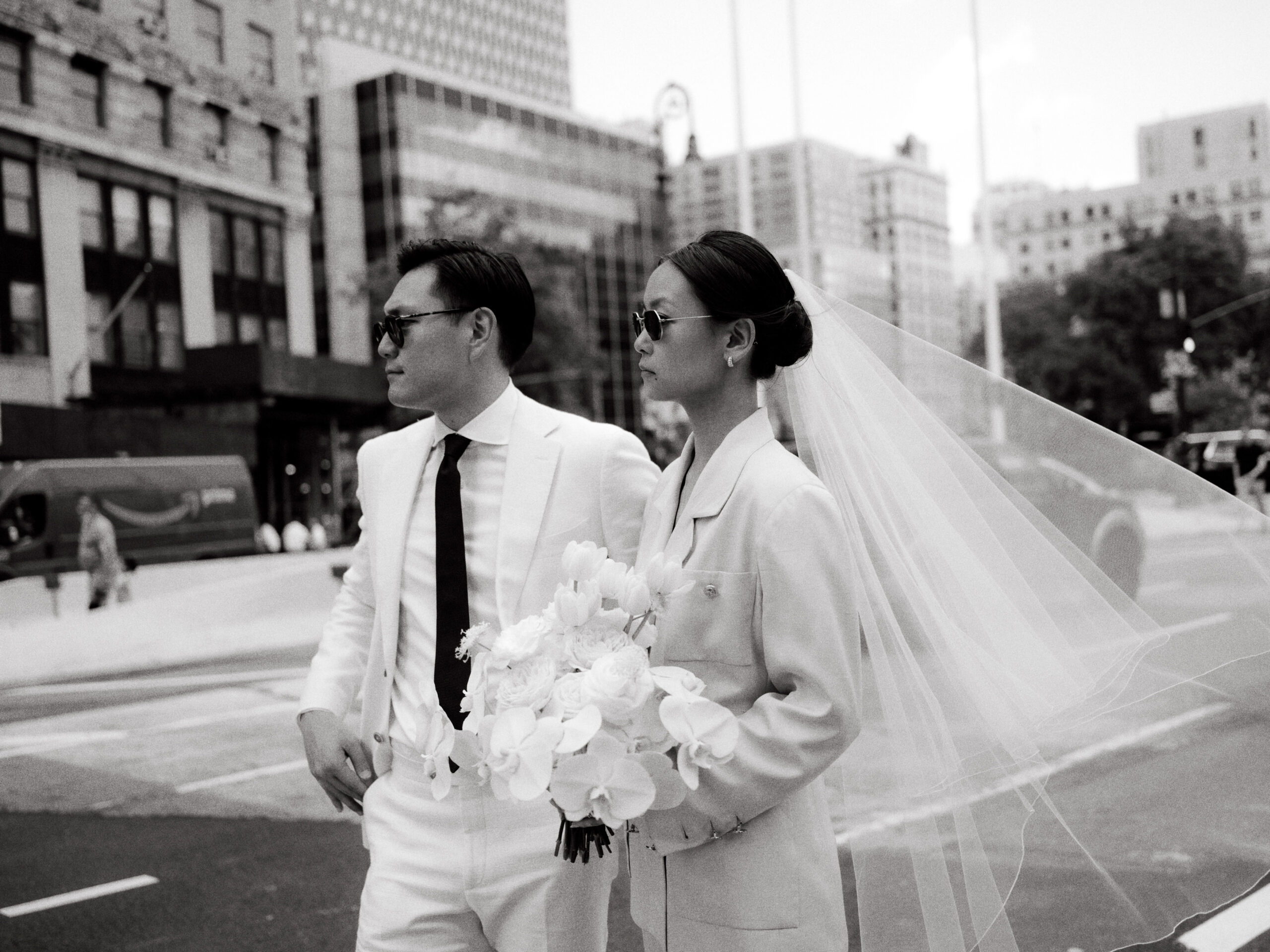 Black and white editorial photo of the bride and groom walking the streets of NY. Image by Jenny Fu Studio