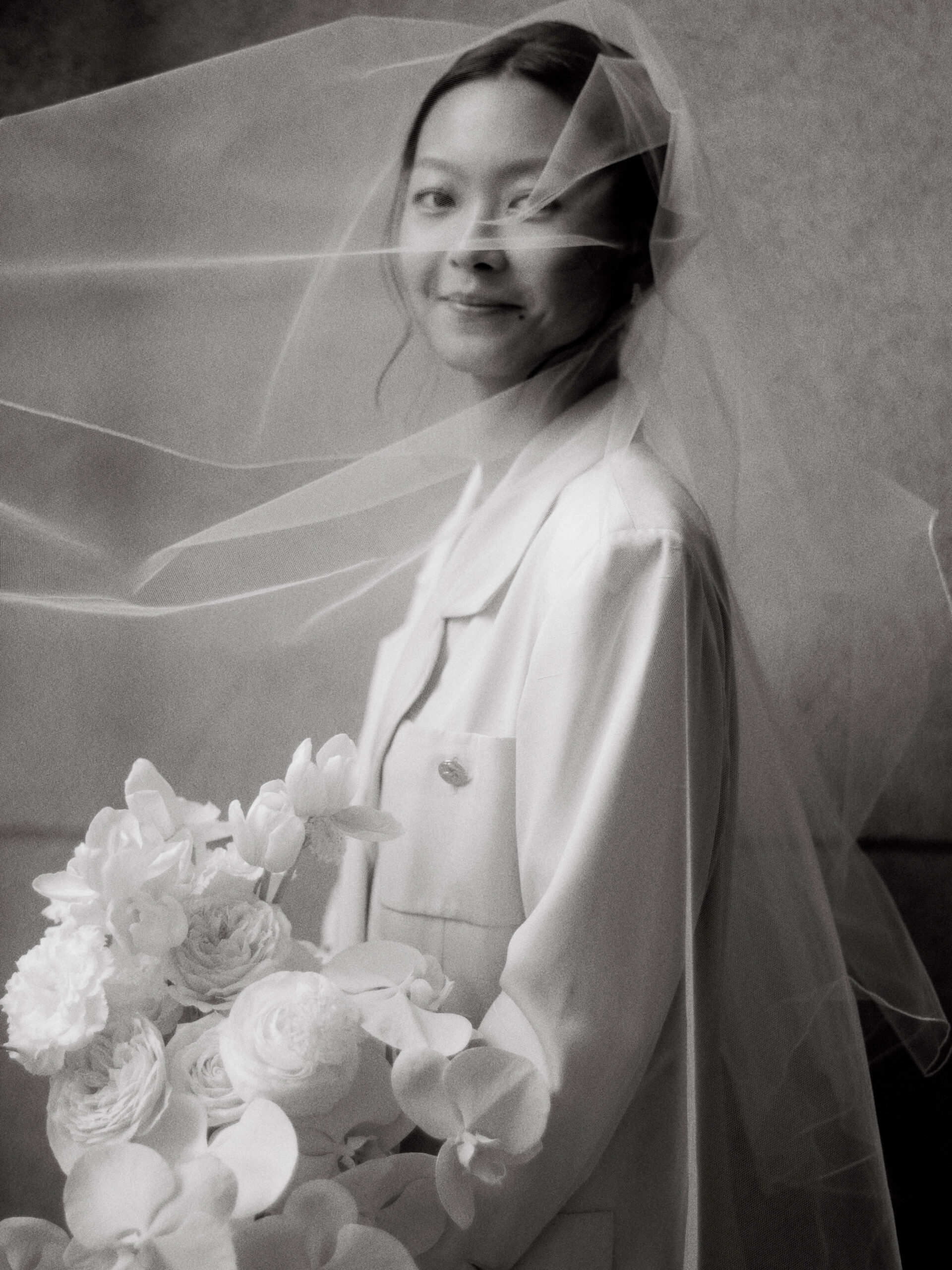 Editorial photo of the bride holding her white monochrome flower bouquet. Image by Jenny Fu Studio