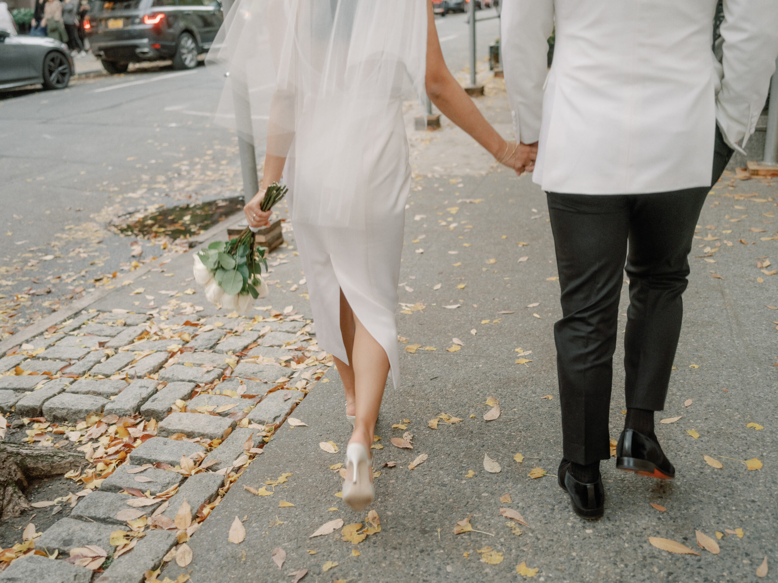 The newlyweds are walking on the streets of New York City. Timeless Wedding Photography image by Jenny Fu Studio