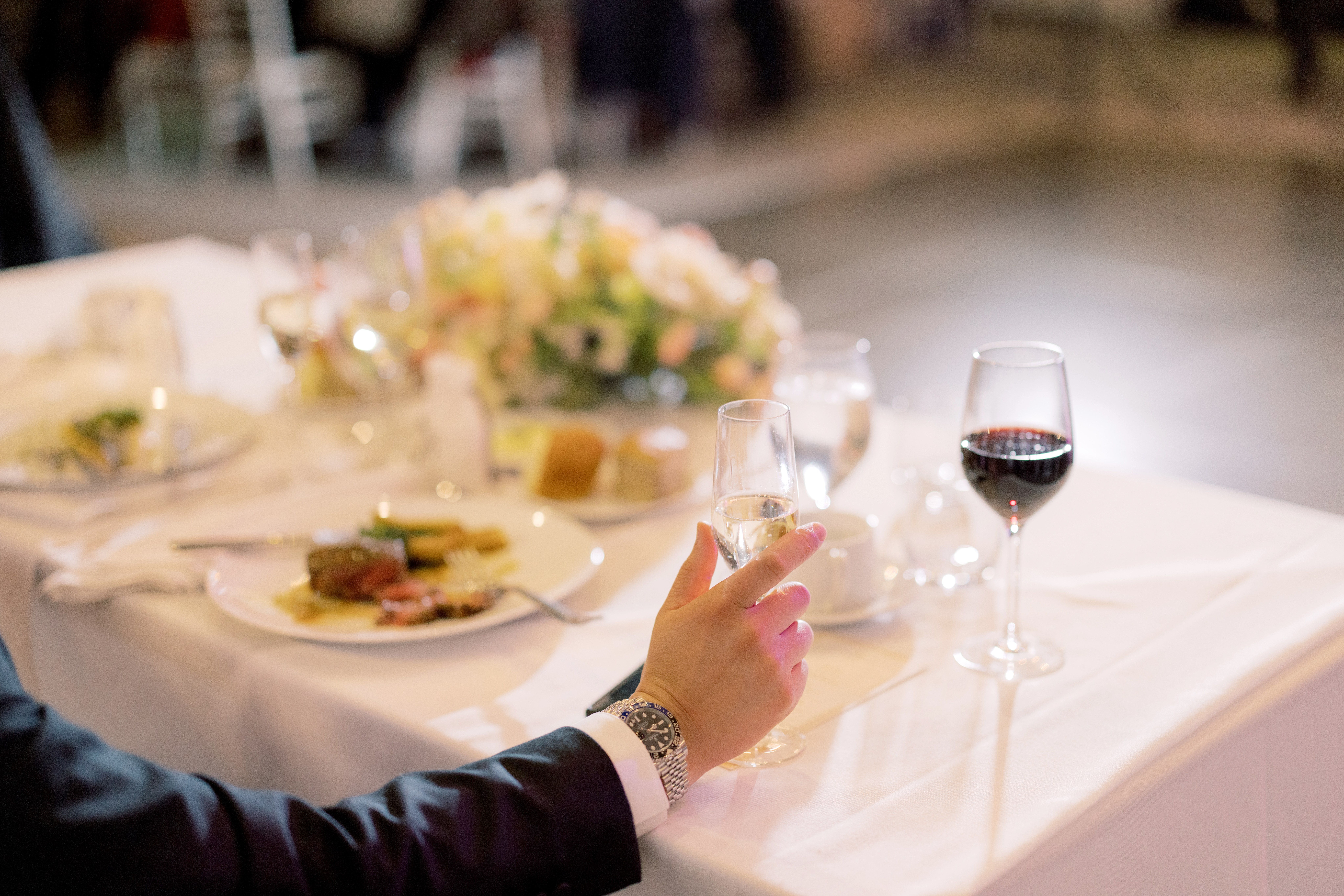Editorial image of the groom eating at the wedding reception. Image by Jenny Fu Studio