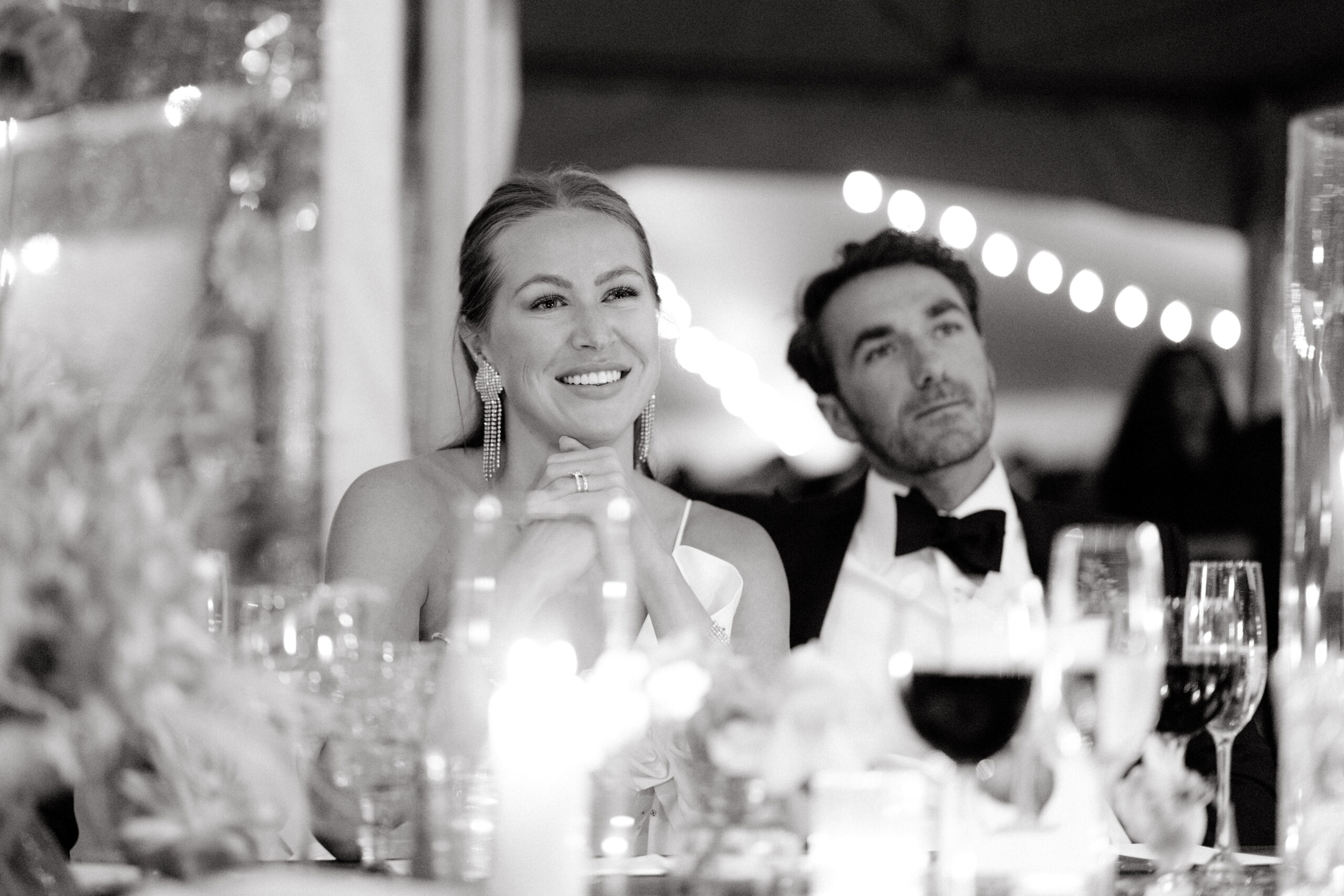 Black and white candid image of the newlyweds in the wedding reception. Image by Jenny Fu Studio