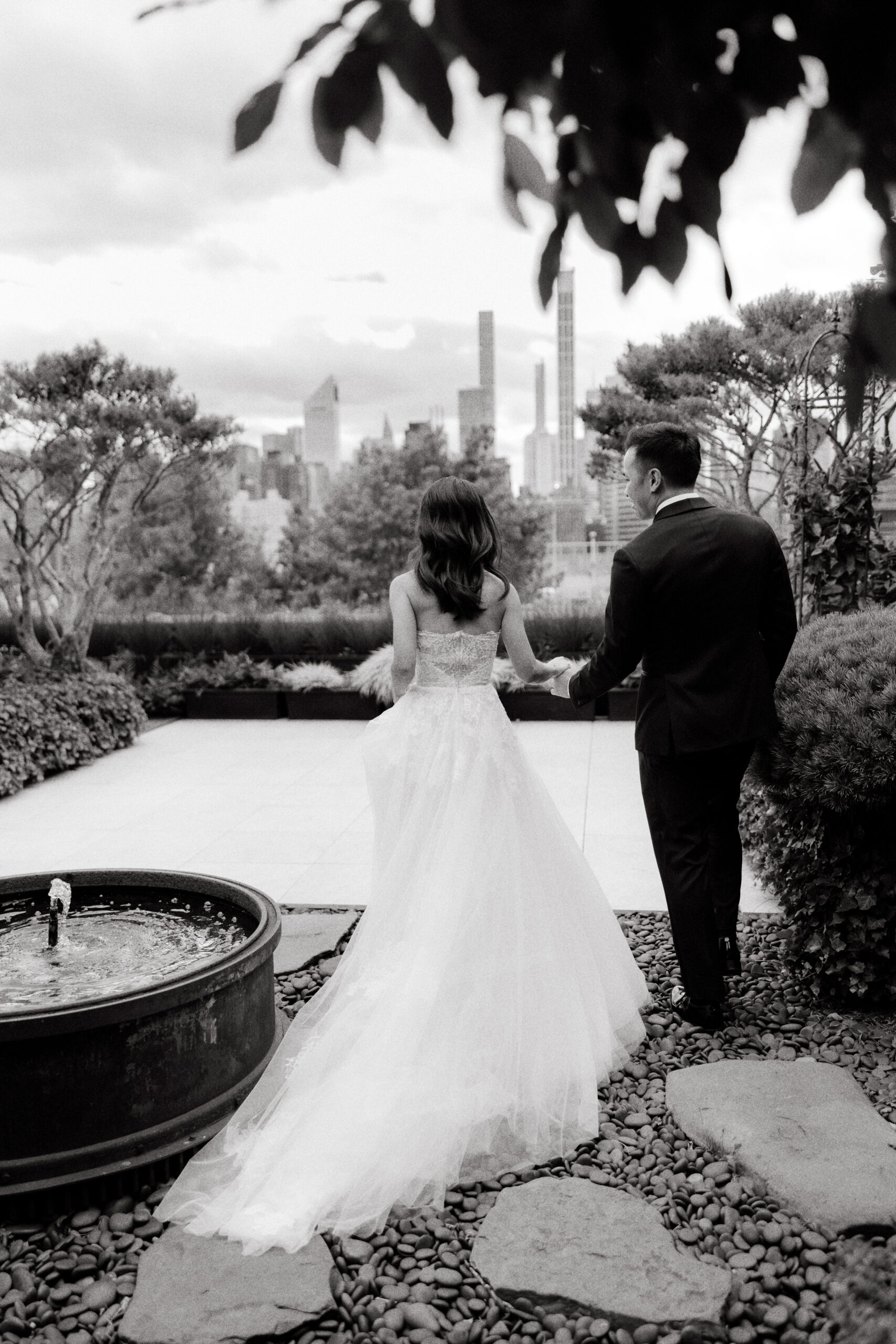 Black and white photo of the bride and groom walking outside. High-quality wedding photography image by Jenny Fu Studio.