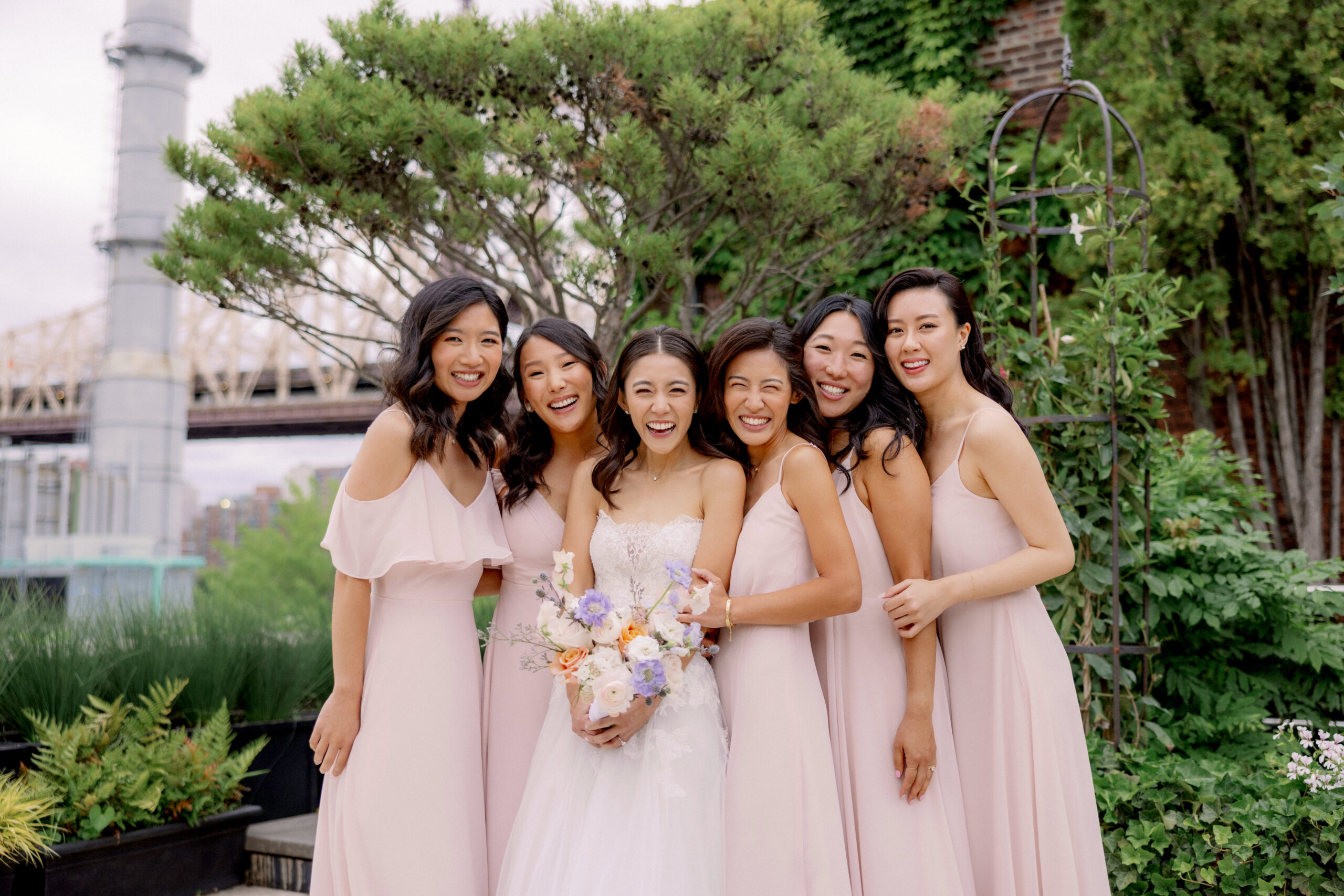 The bride and the bridesmaids with The Brooklyn Bridge in the background. High-quality wedding photography image by Jenny Fu Studio.