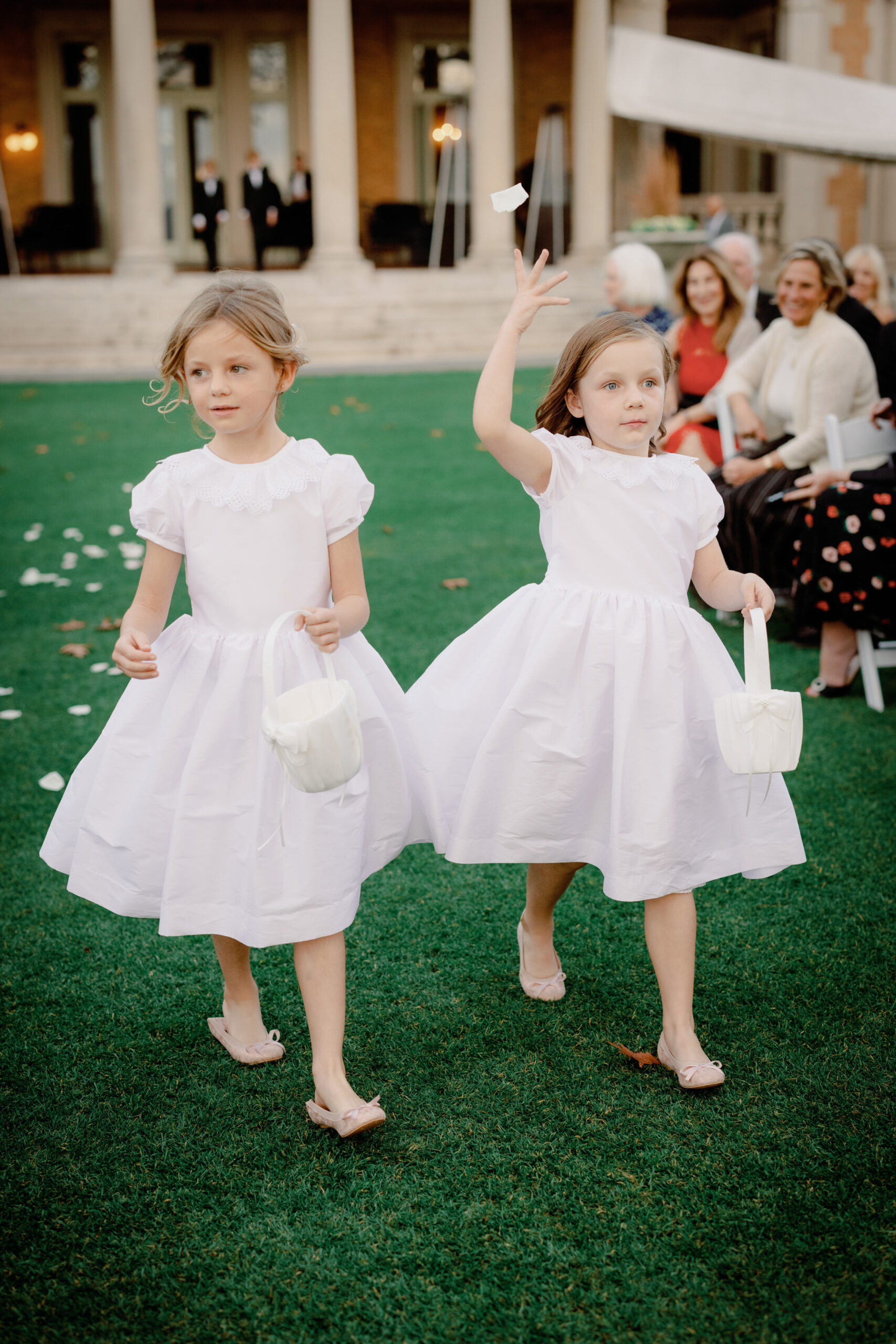 Cute flower girls dropping flower petals while walking in the aisle. Outdoor wedding photography image by Jenny Fu Studio