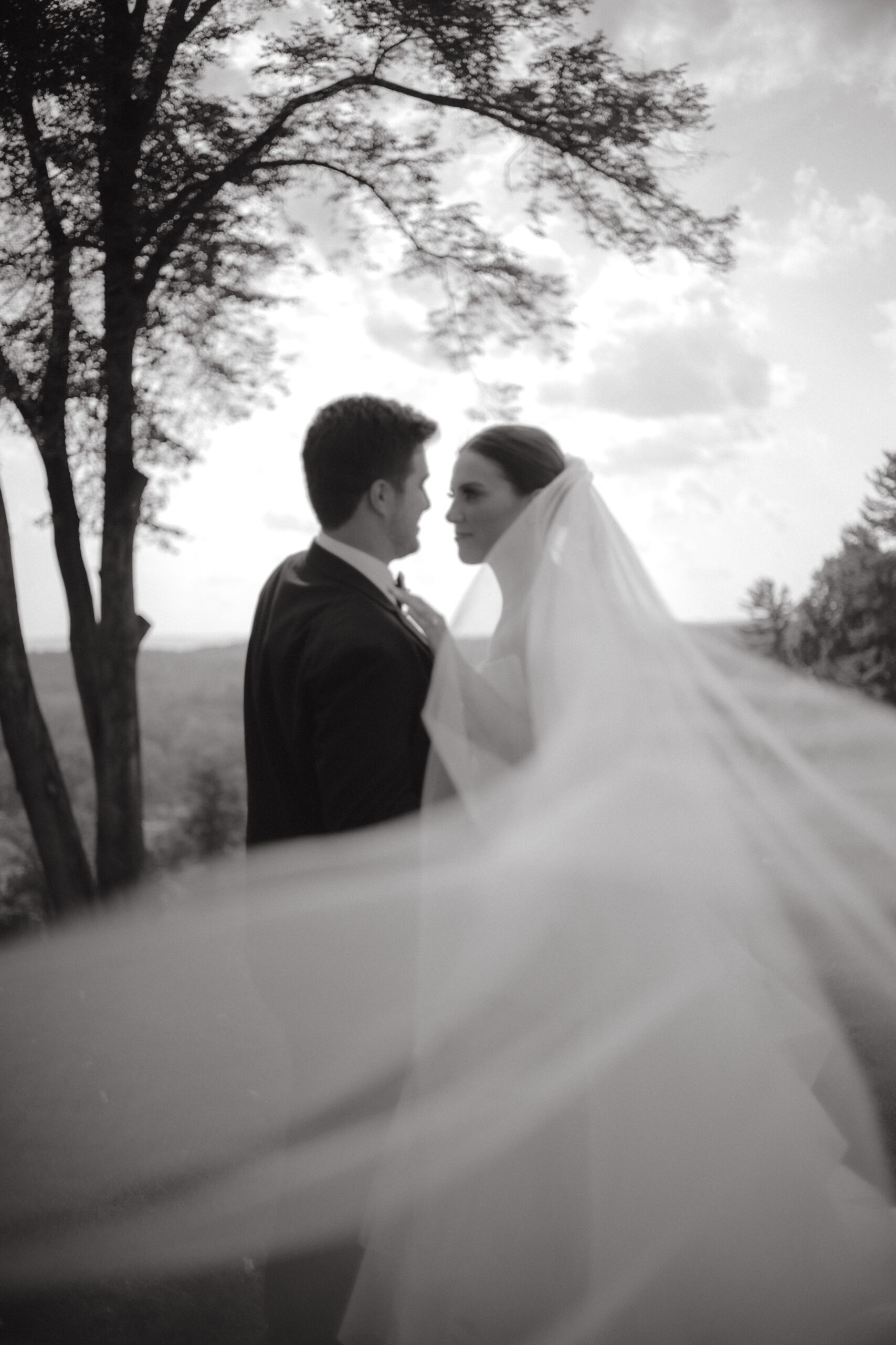 Black and white timeless wedding image of the newlyweds outdoors. Image by Jenny Fu Studio