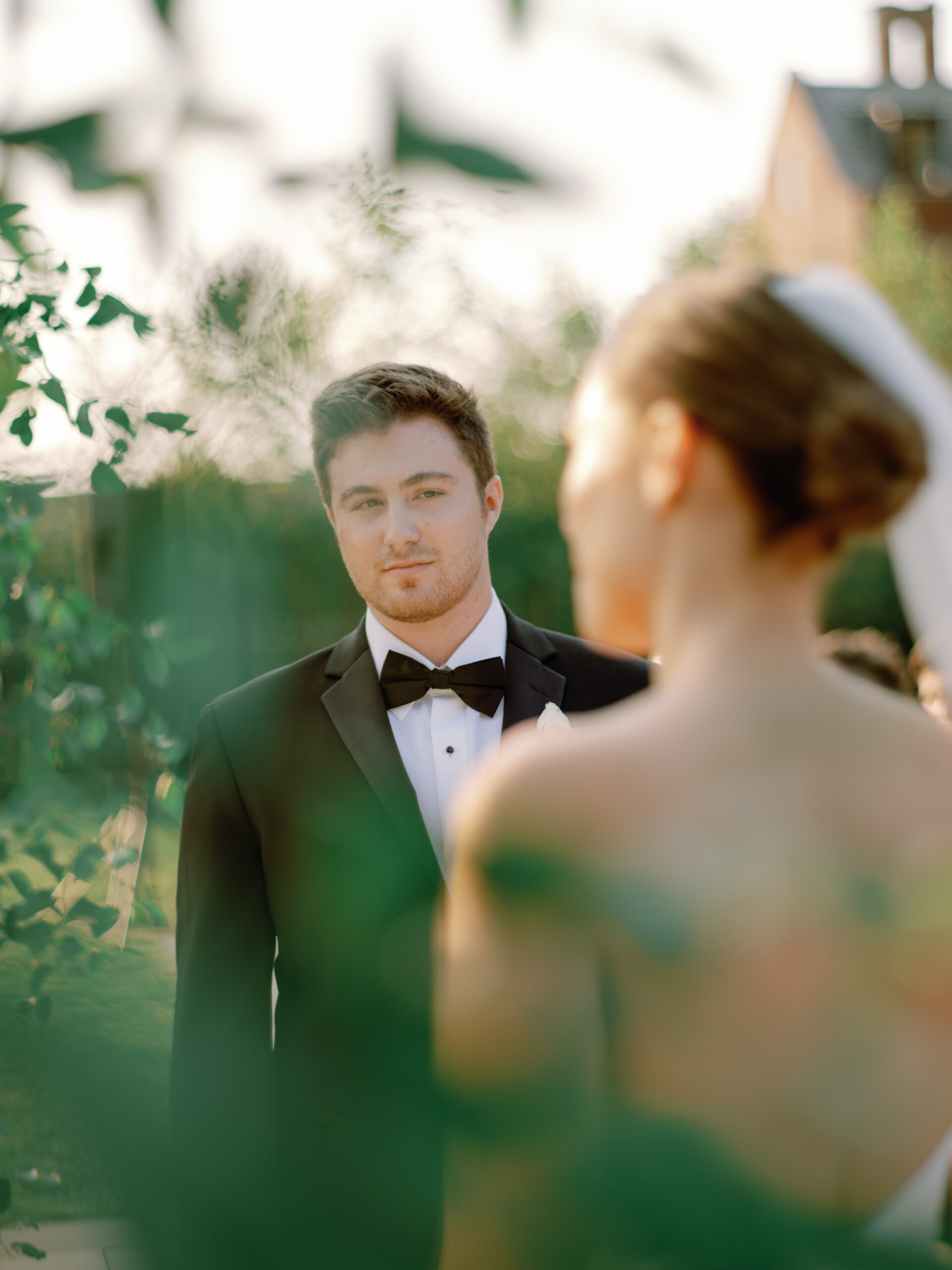 Candid photo of stolen glances of the groom during the wedding ceremony. Image by Jenny Fu Studio