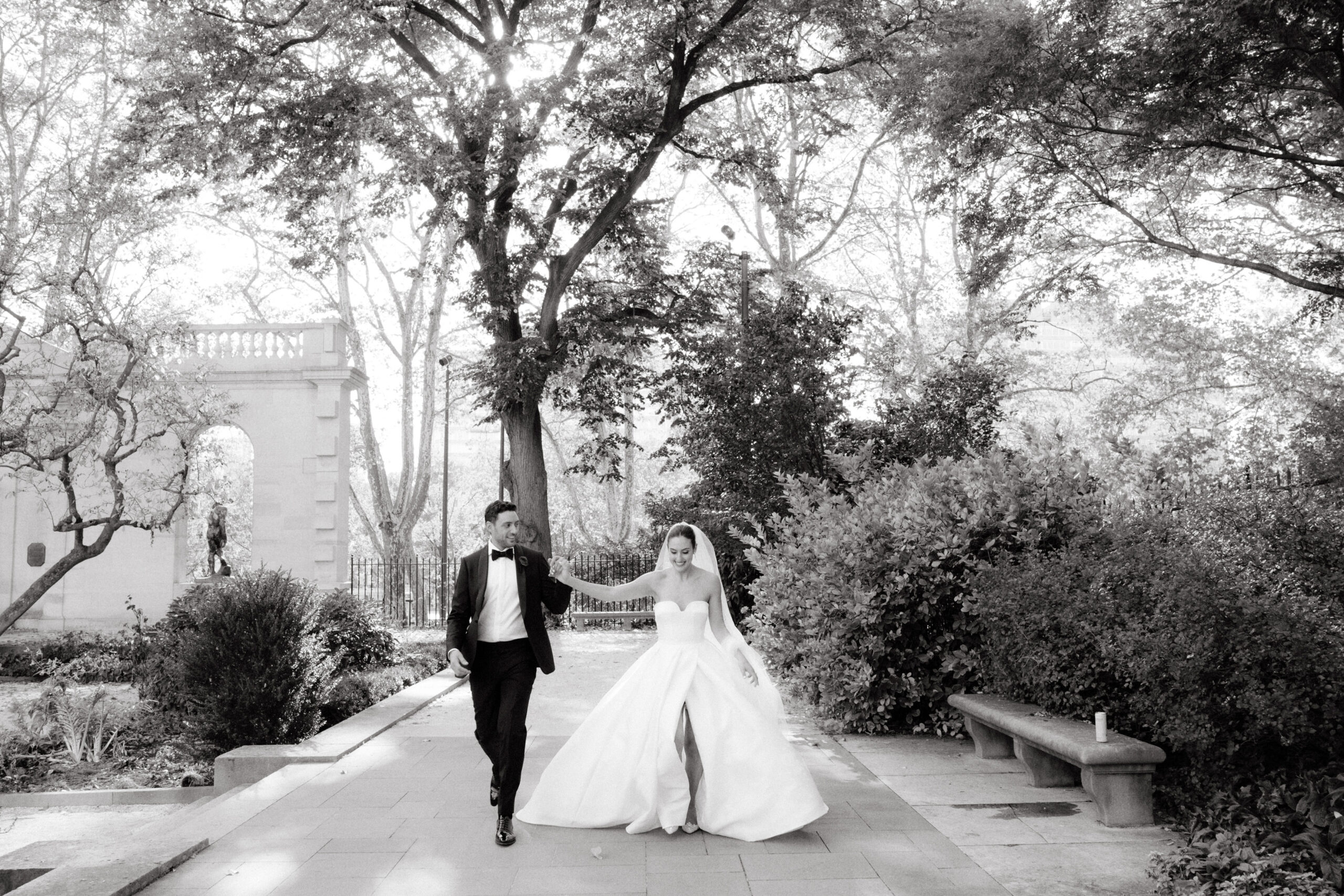 Black and white, candid photo of the newlyweds walking outdoors. Chic celebration image by Jenny Fu Studio