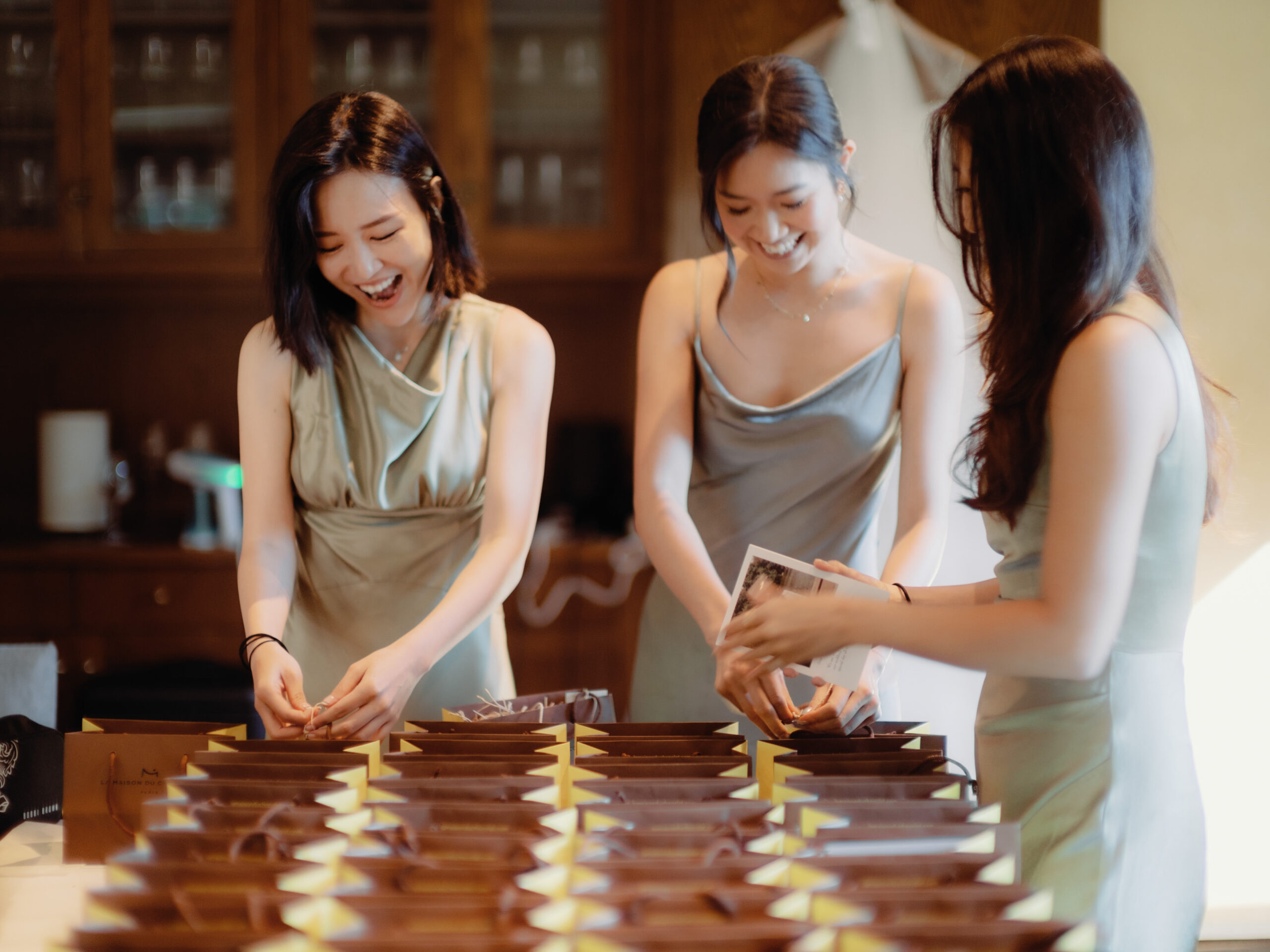 The bridesmaids are happily preparing the wedding favors. Candid wedding photography image by Jenny Fu Studio