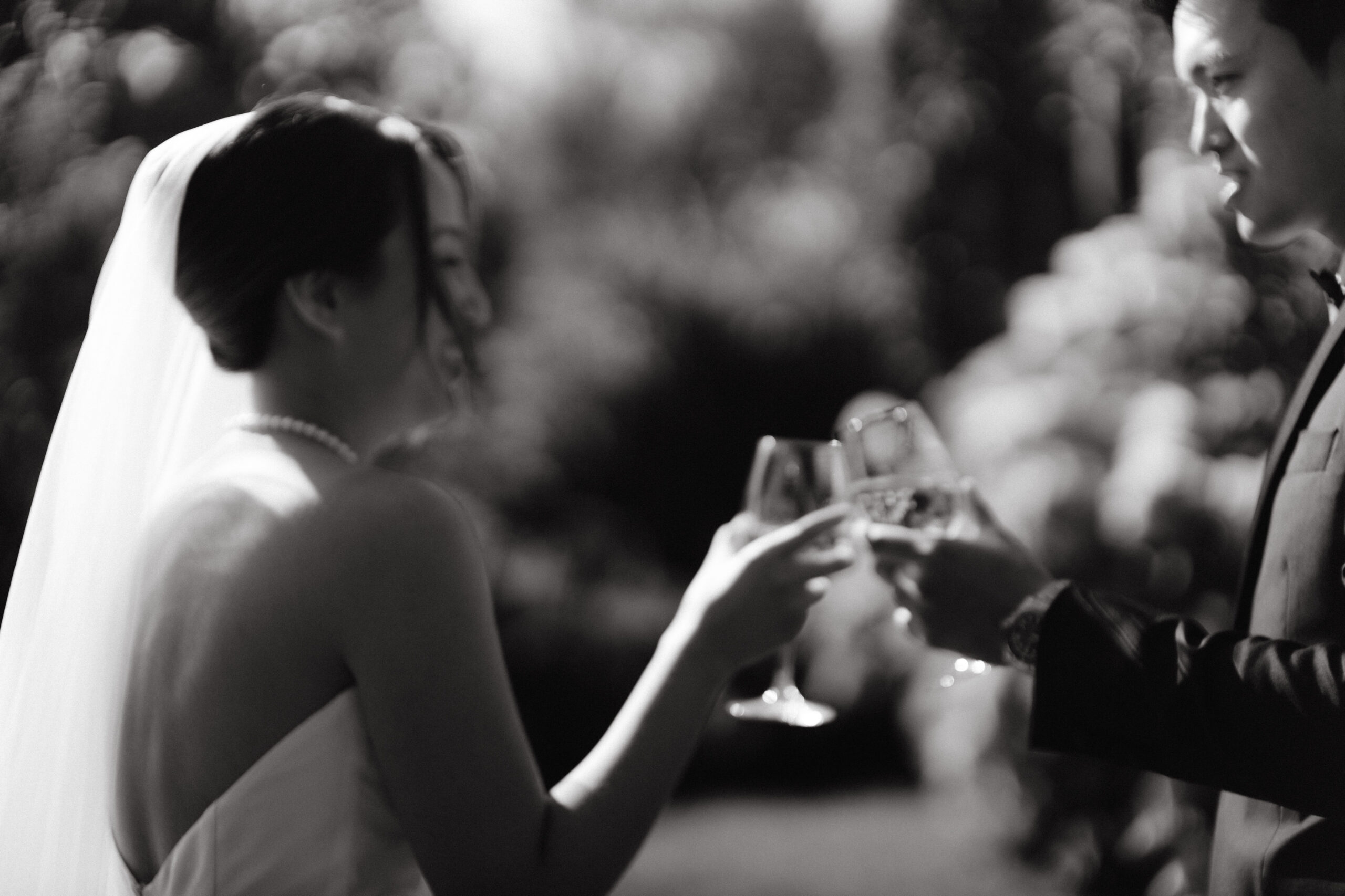 Black and white image of the bride and groom enjoying a toast. Candid wedding photography image by Jenny Fu Studio