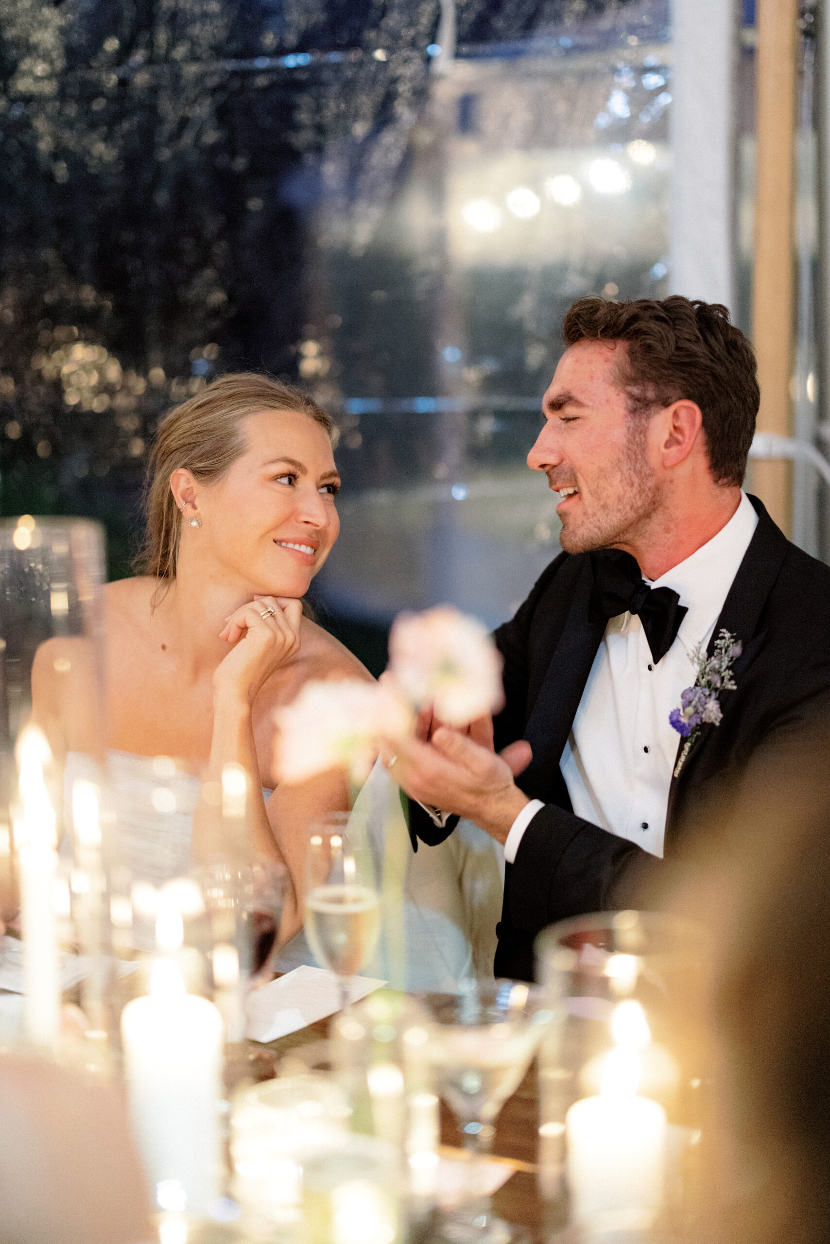 Candid shot of the newlyweds romantically smiling at each other in their wedding reception in the Adirondacks, NY.