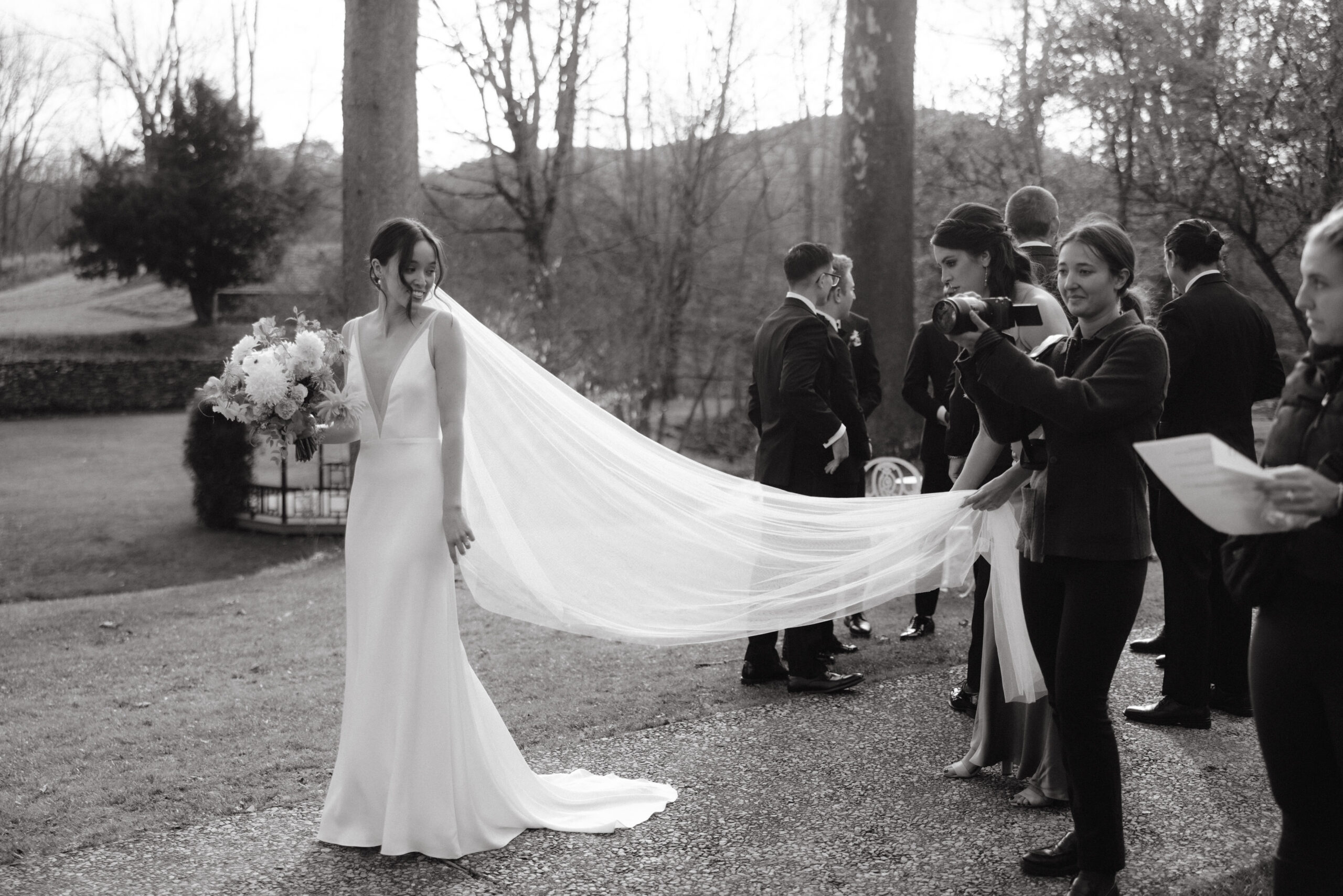 Black and white image of the bride, outdoors, in her stunning gown. Photojournalistic wedding photography image by Jenny Fu Studio