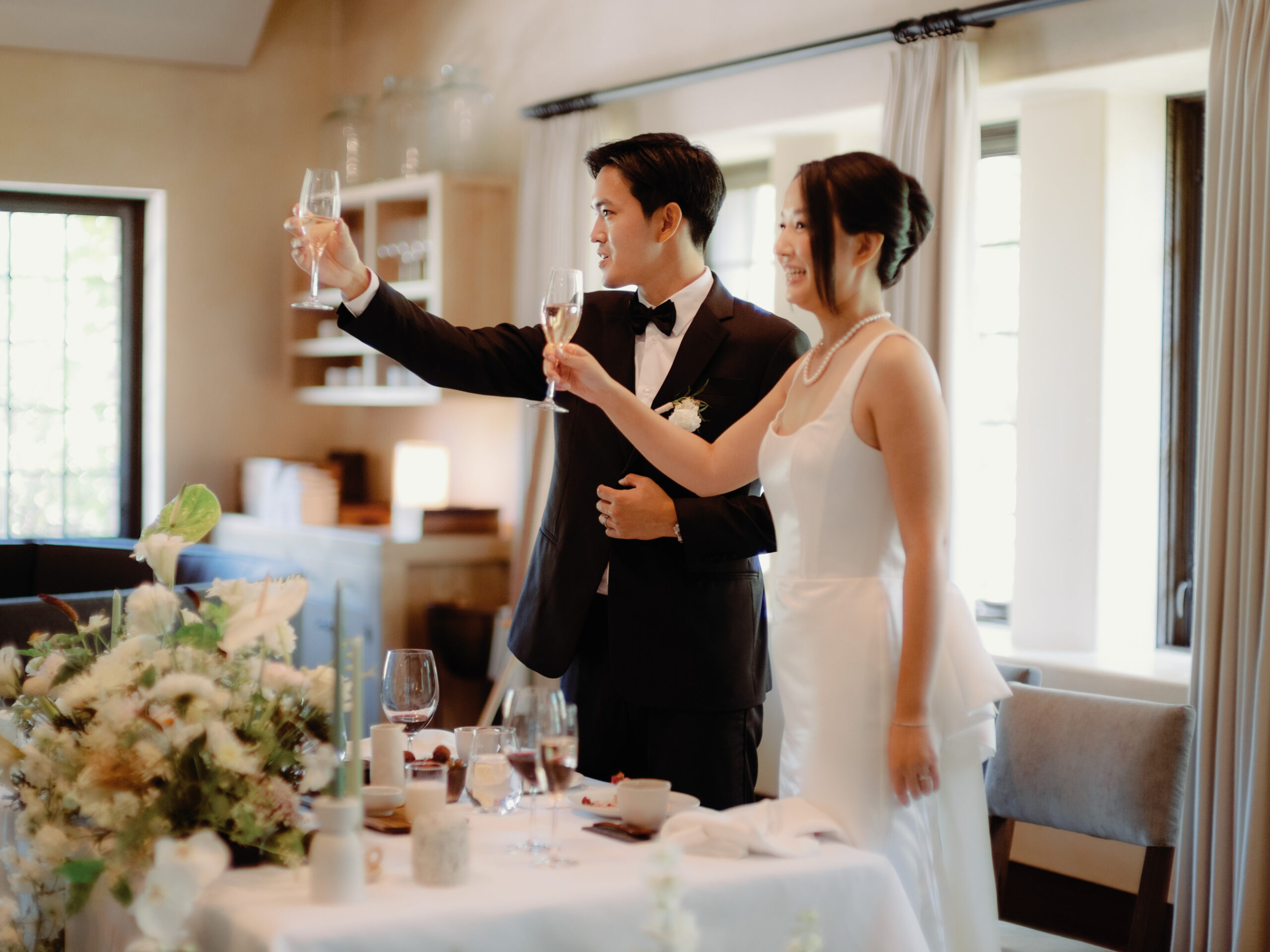 The bride and groom raise their Champagne glasses in the ceremonial toast. Image by Jenny Fu Studio 