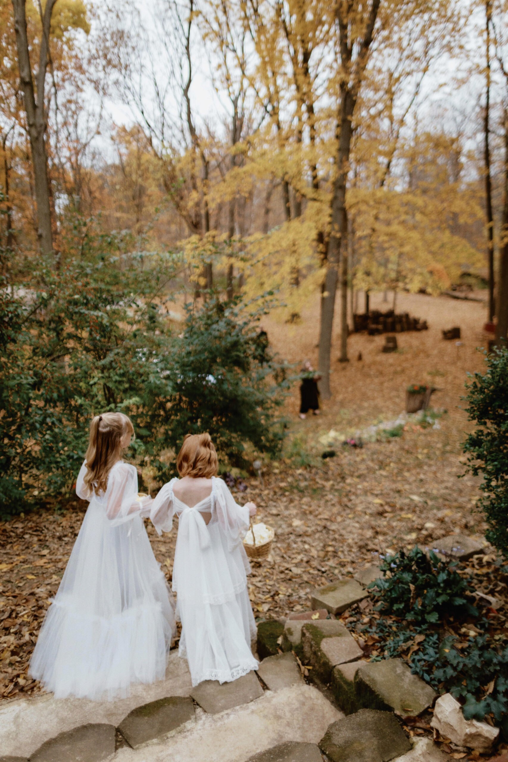 The flower girls, wearing beautiful dresses, are walking towards the aisle in Indiana. Documentary wedding photography image by Jenny Fu Studio