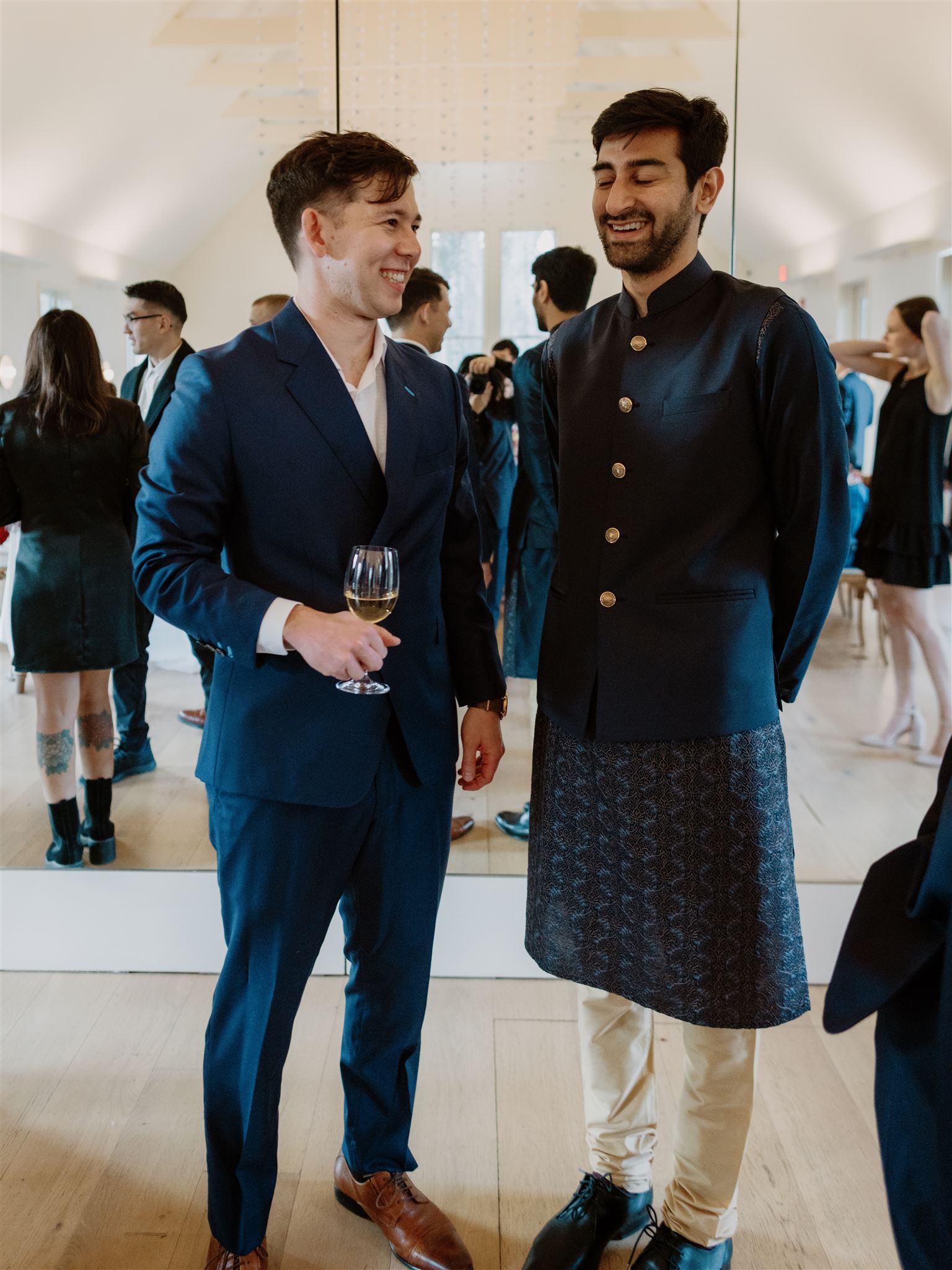 The groom-to-be is happily chatting with a guest at their welcome dinner in New York. Photojournalistic photography image by Jenny Fu Studio