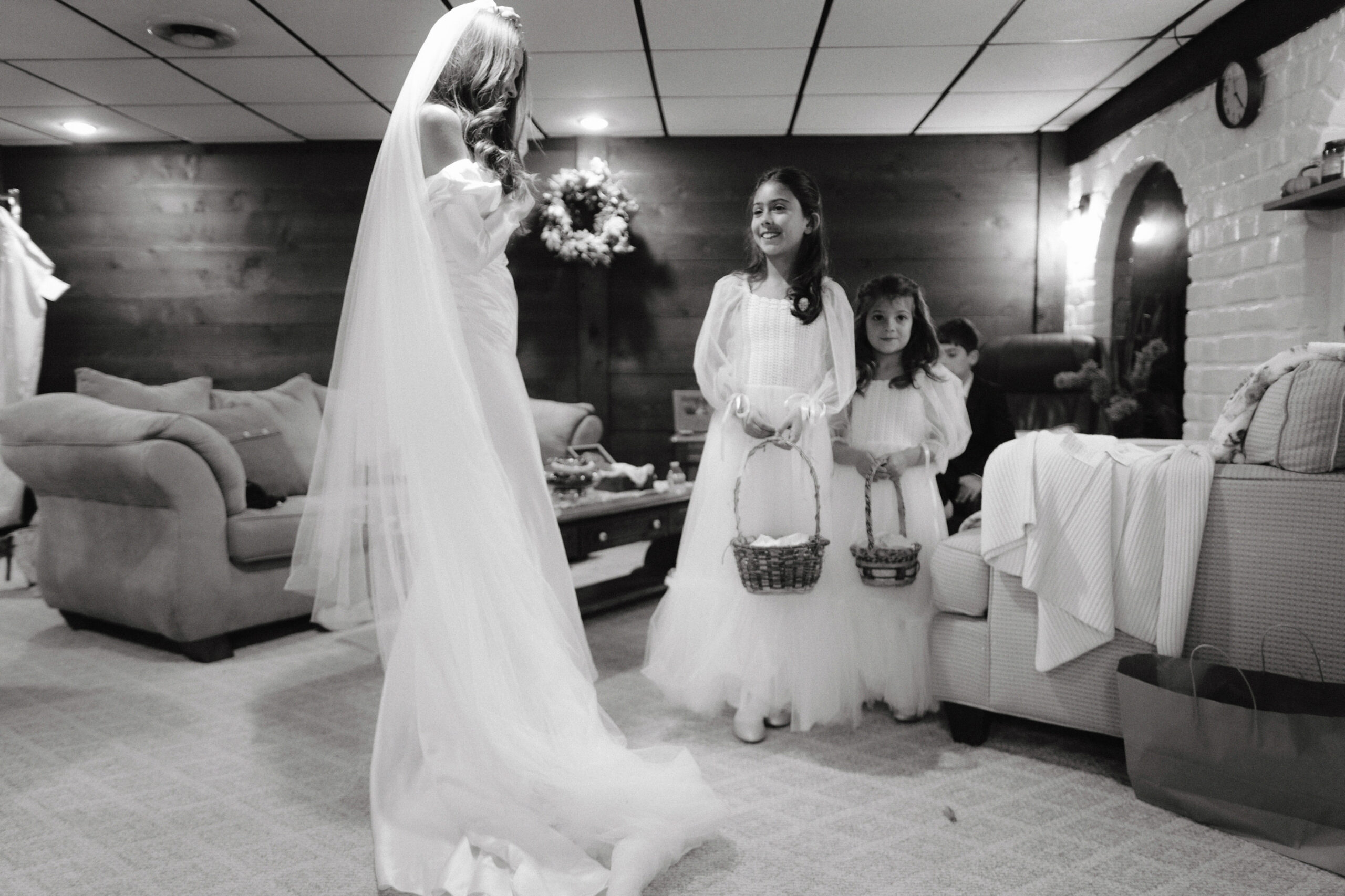 Black and white getting ready photo of the bride with her flower girls. Candid wedding photography image by Jenny Fu Studio