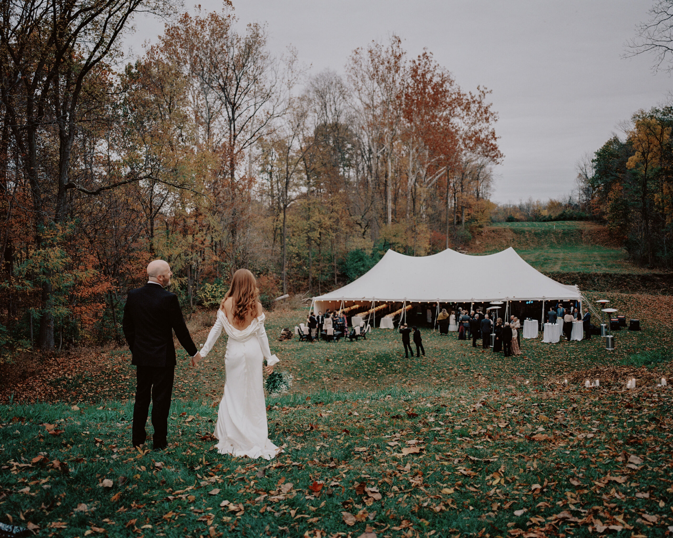 The newlyweds are walking towards the wedding reception outdoors. Image by Jenny Fu Studio