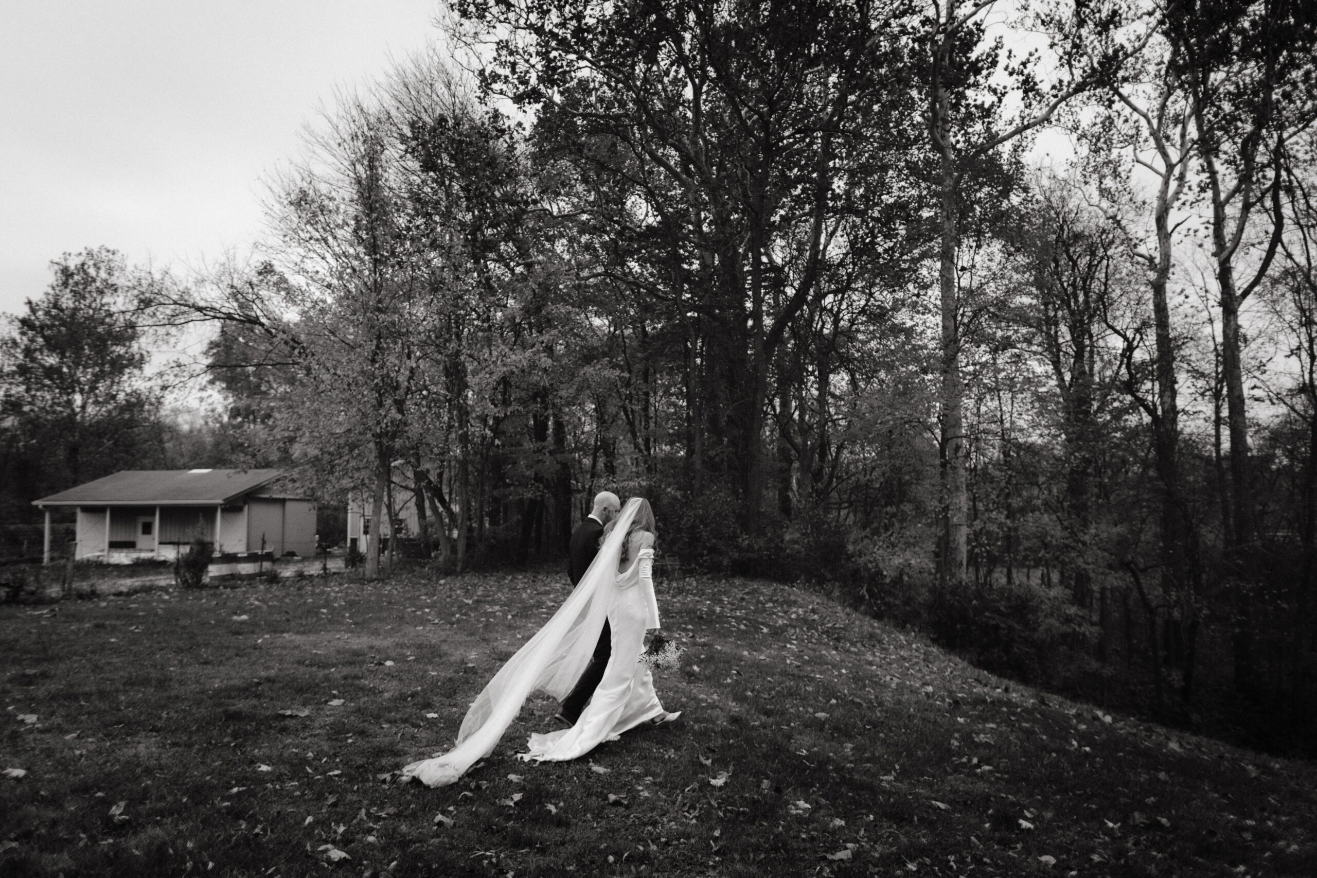 Black and white documentary wedding photo of the newlyweds walking outdoors by Jenny Fu Studio