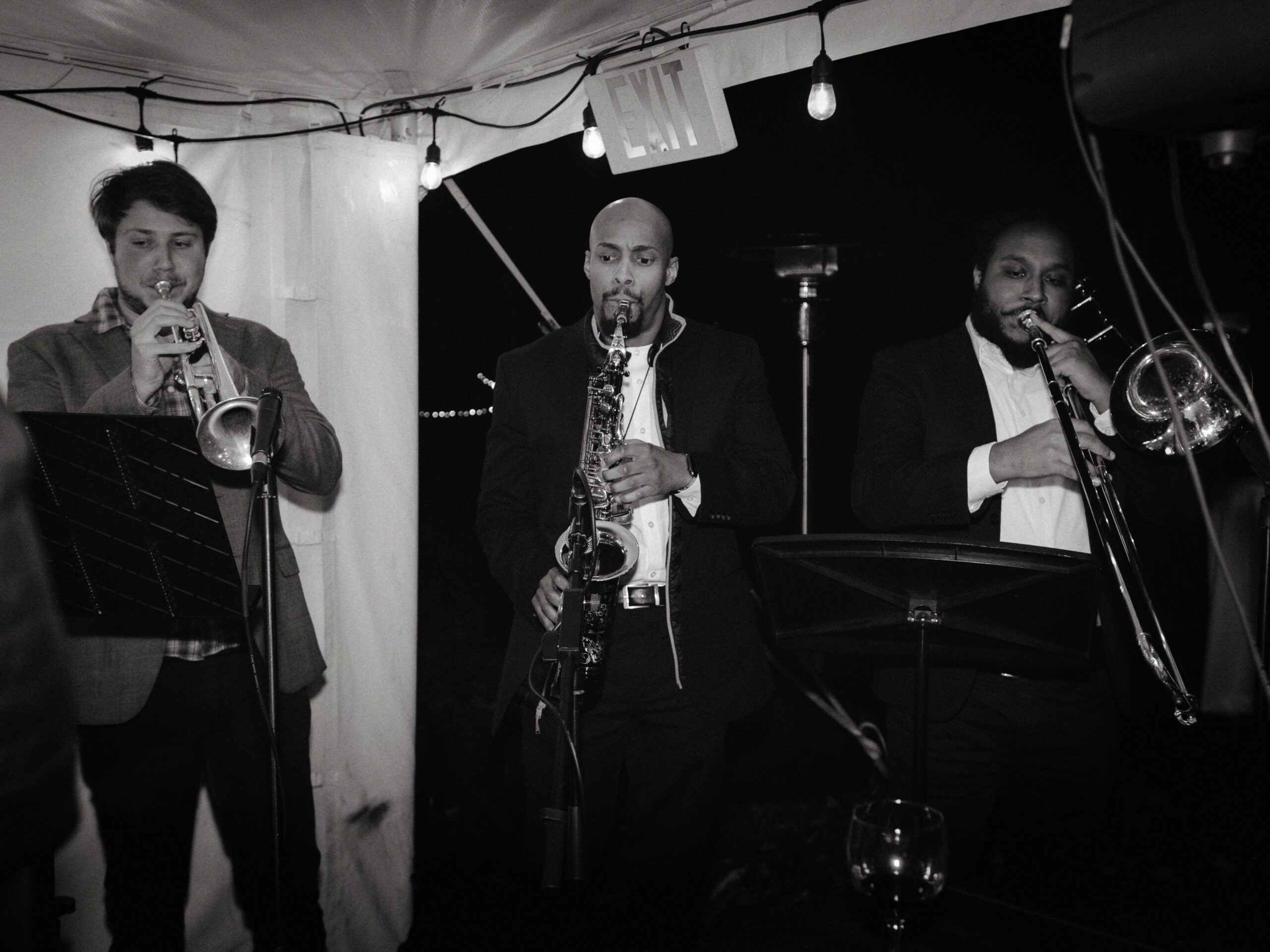Black and white image of the band playing different instruments at a wedding reception. Image by Jenny Fu Studio 