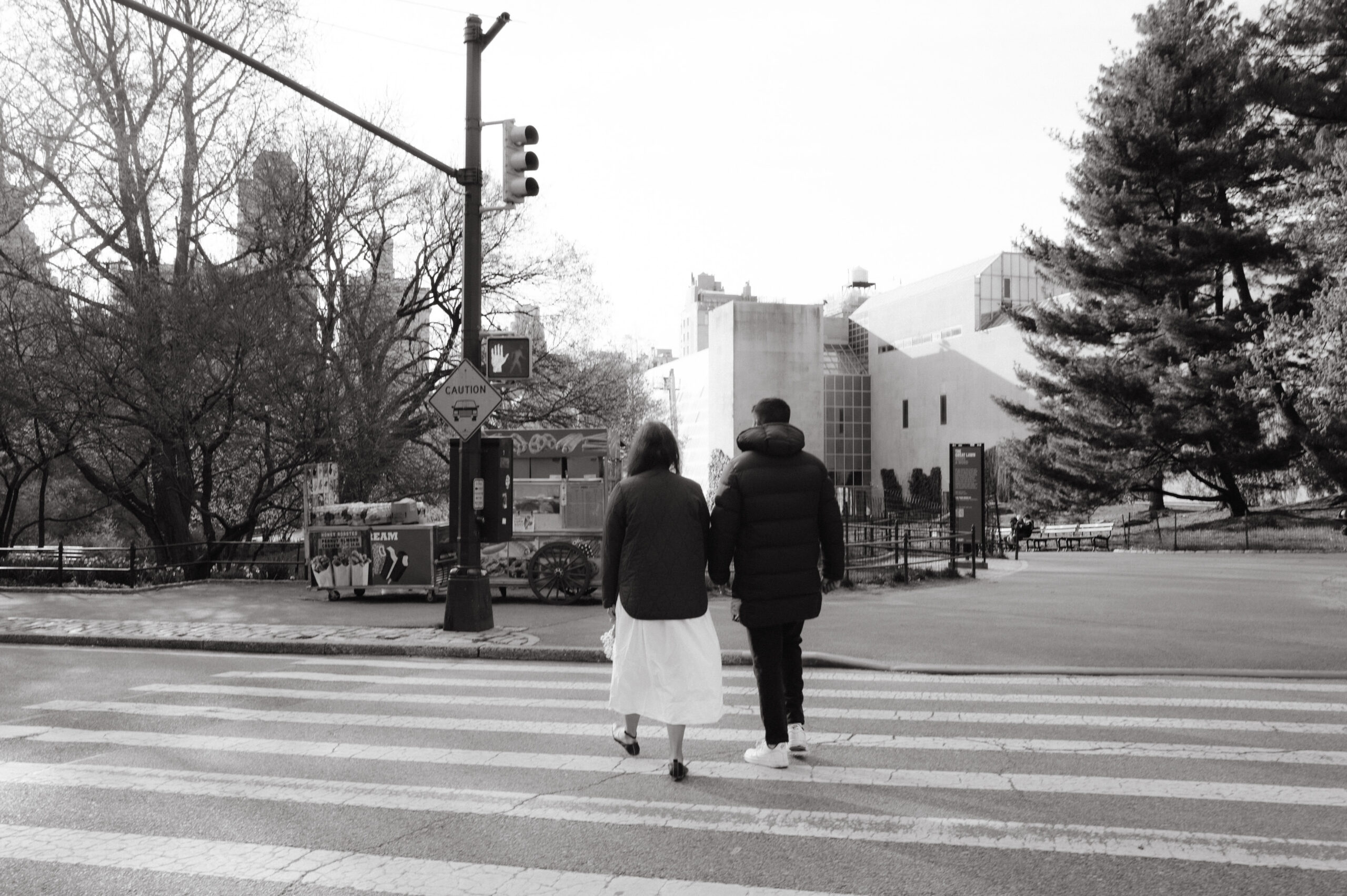 The engaged couple is crossing a pedestrian lane in NYC. Image by Jenny Fu Studio