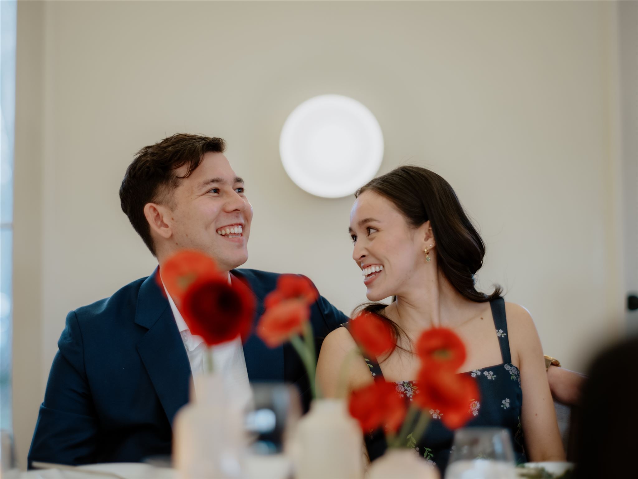 The soon to be husband and wife are smiling as they enjoy the welcome dinner. Wedding weekend image by Jenny Fu Studio