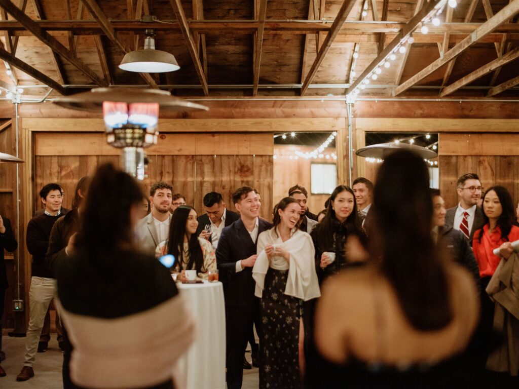 The couple are happily laughing with their guests in their welcome dinner. Image by Jenny Fu Studio