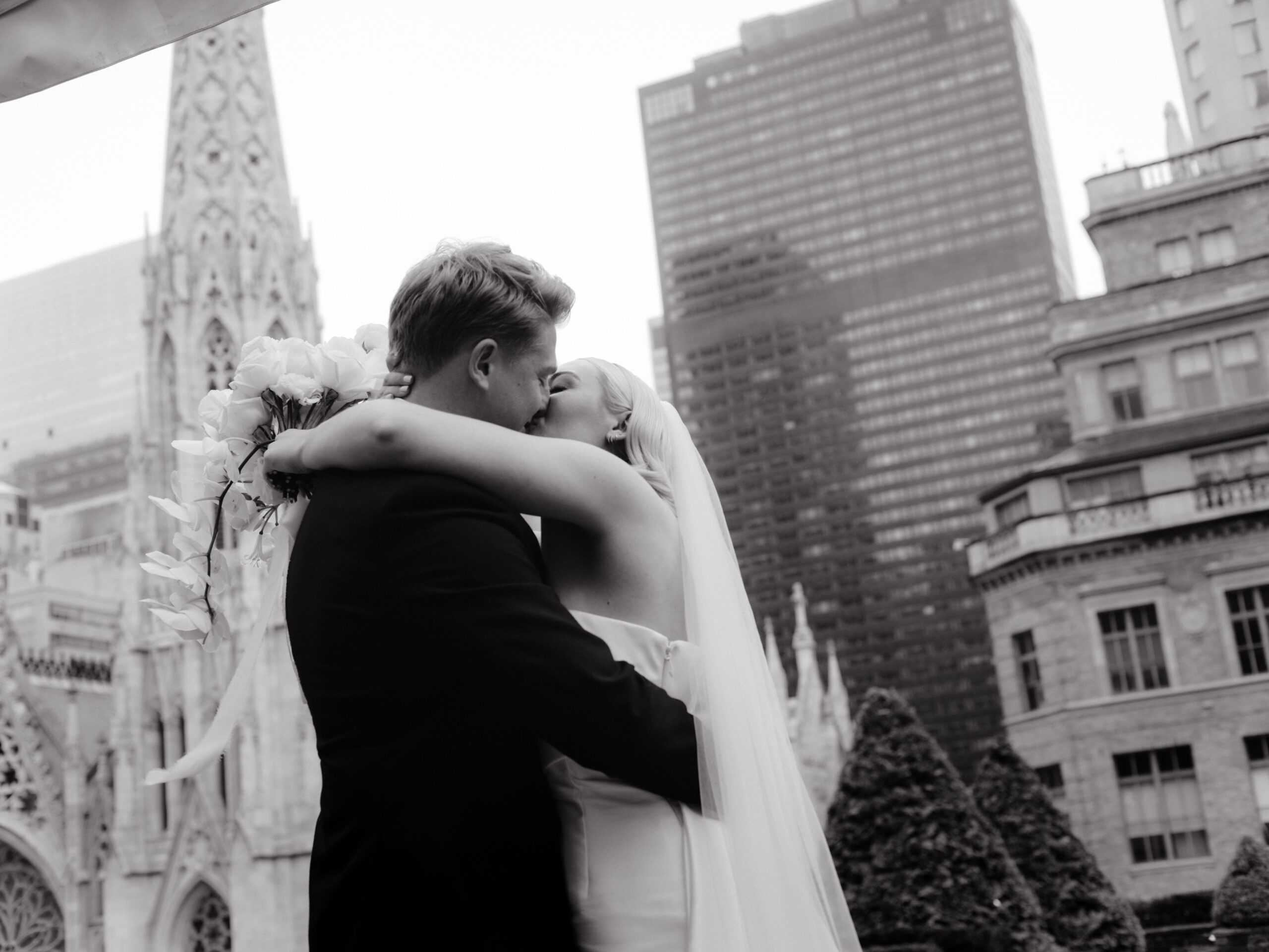 The newlyweds are kissing each other after the wedding ceremony at 620 Loft and Garden, overlooking St. Patrick's Cathedral. Image by Jenny Fu Studio