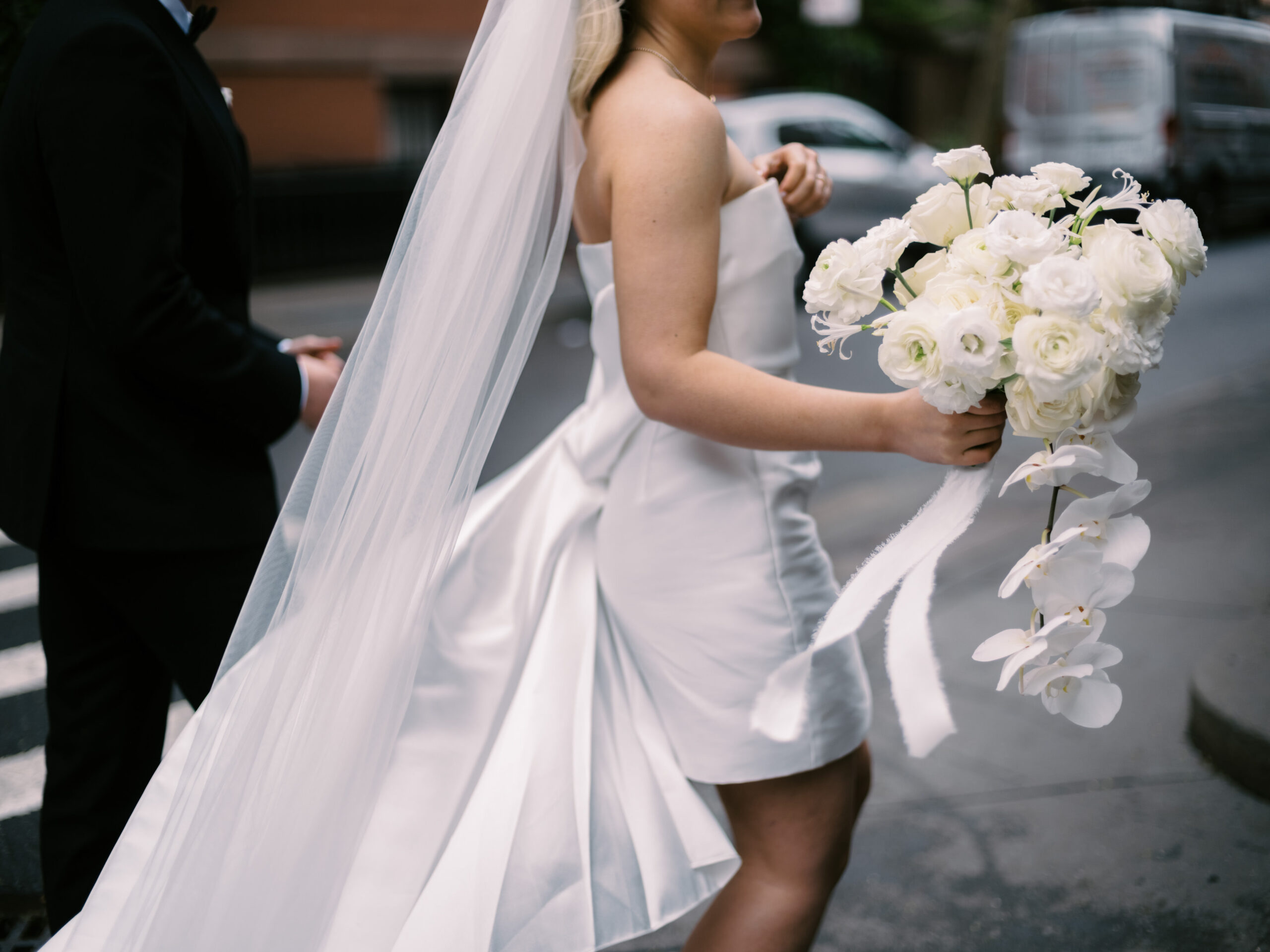 Close-up shot of the bride in her wedding dress, holding a pretty white flower bouquet. Image by Jenny Fu Studio