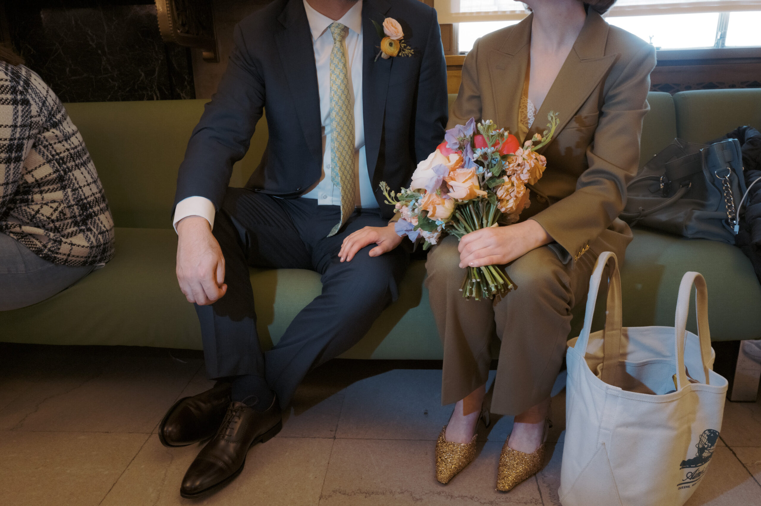 Half body shot of the bride and groom while sitting in the City Clerk's office couch in NYC. NYC City Hall Elopement image by Jenny Fu Studio 