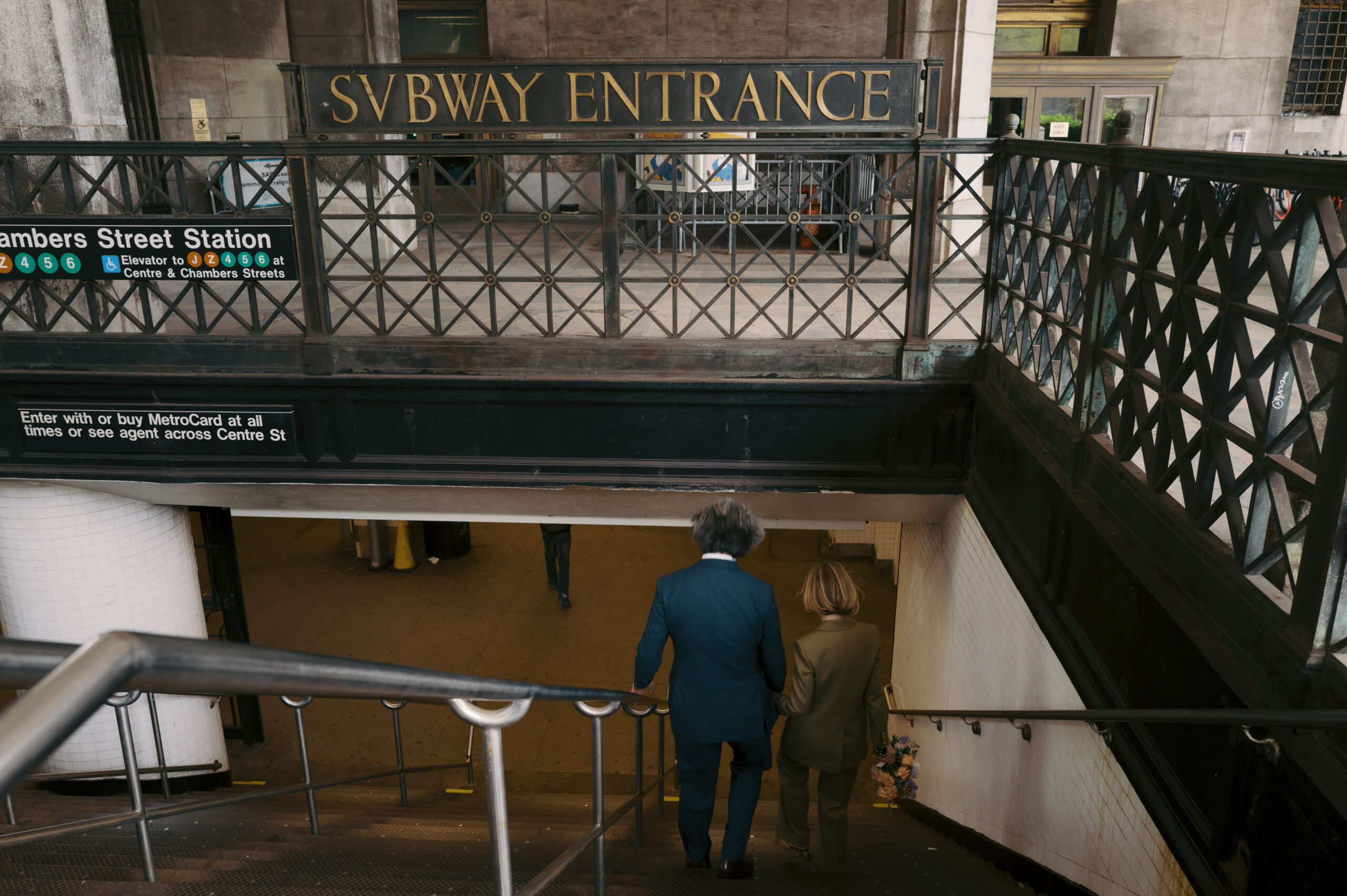 The newlyweds are walking down the staircase of an NYC subway entrance. Image by Jenny Fu Studio