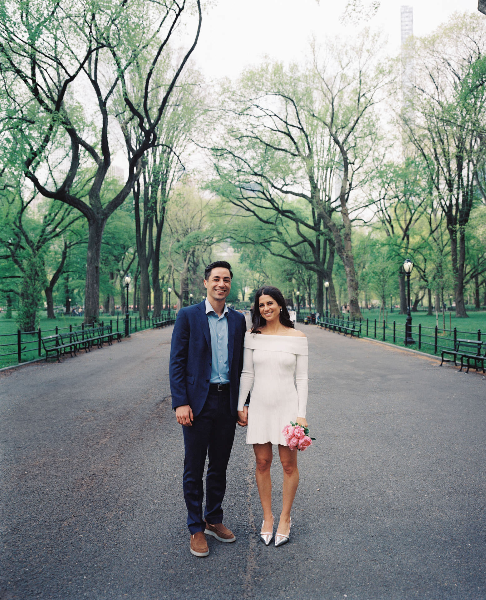 A couple walking down the tree-lined promenade of The Mall, surrounded by the lush canopy of American elm trees.