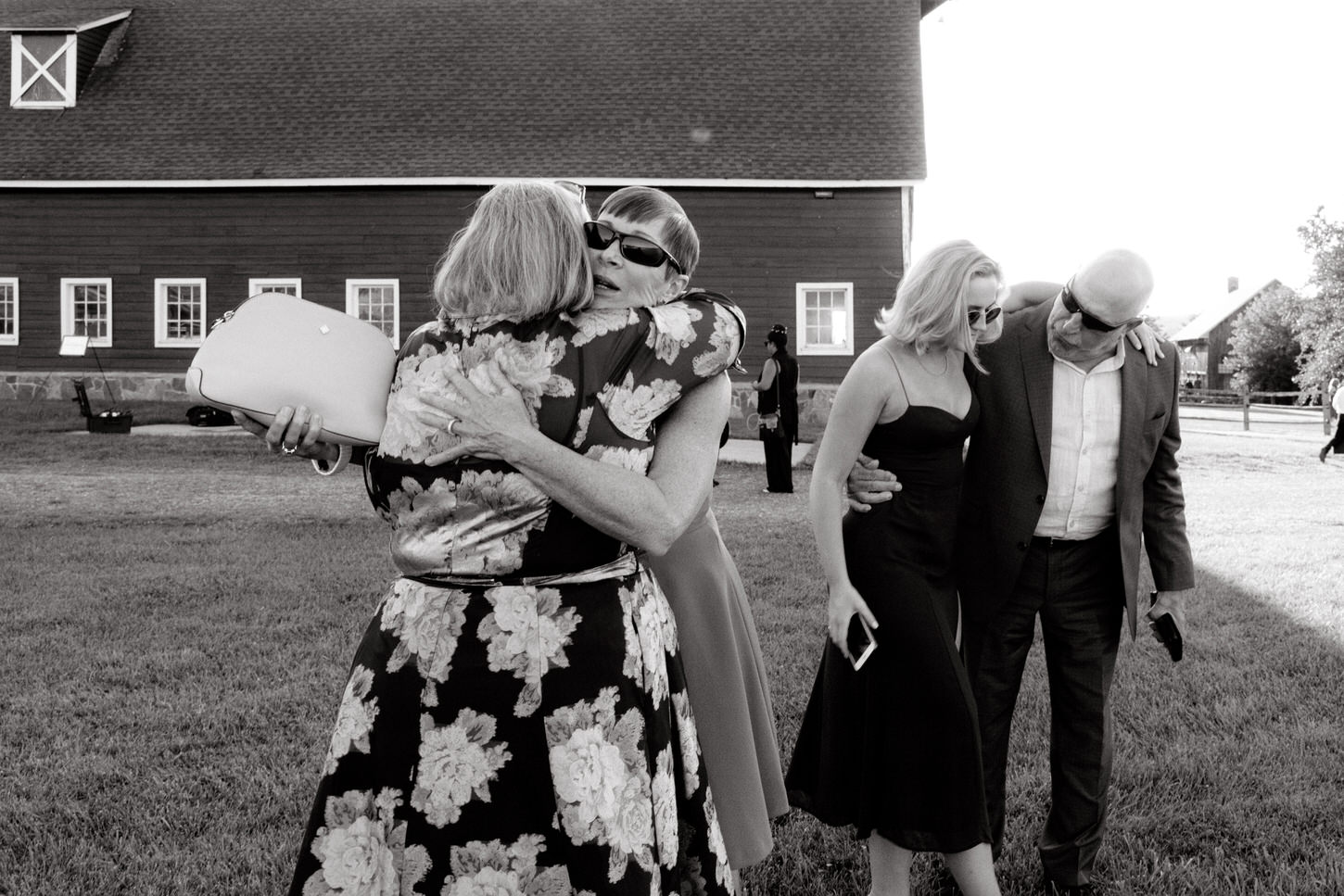 Black and white image of guests greeting each other at a day-after-wedding brunch in a farm, by Jenny Fu Studio