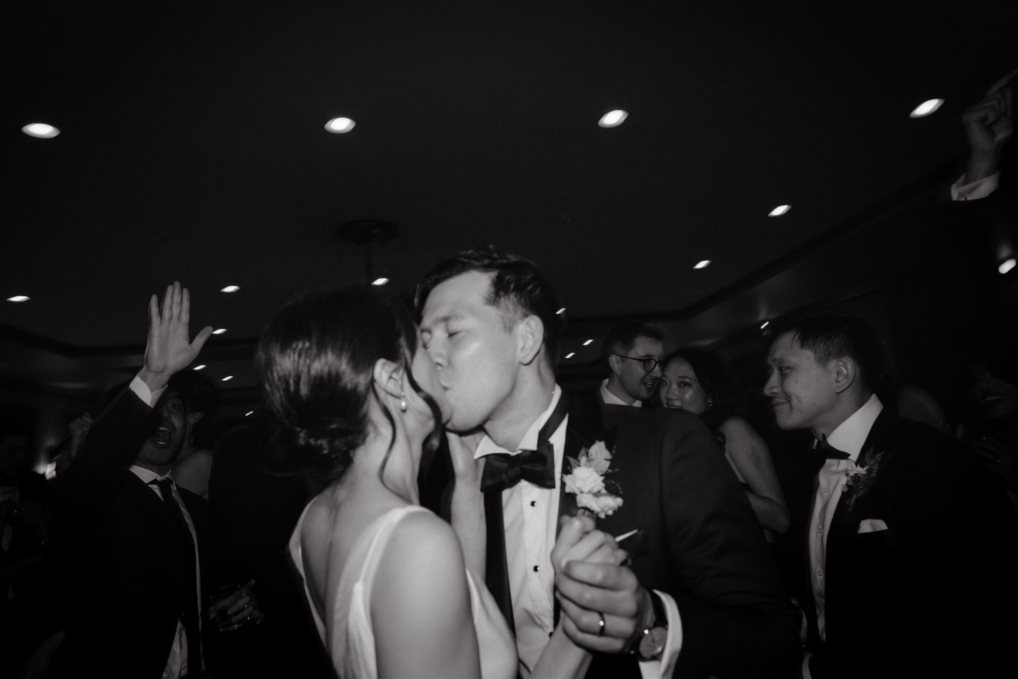 The newlyweds are lovingly kissing each other on the dance floor in the wedding reception. Photojournalistic Wedding Photography image by Jenny Fu Studio